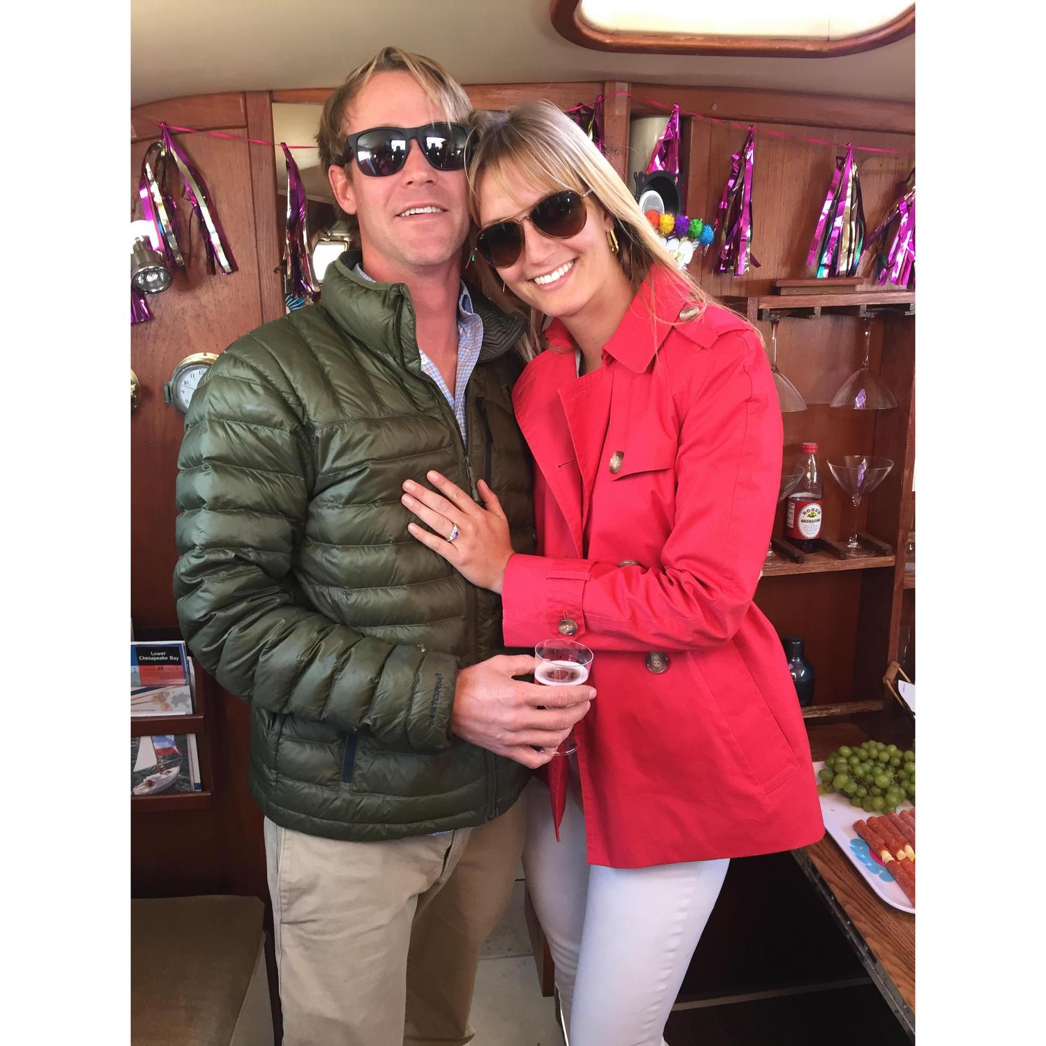 Celebrating the engagement with champagne in the salon of our sailboat! Peter built the bar and table behind us with beautiful oak!