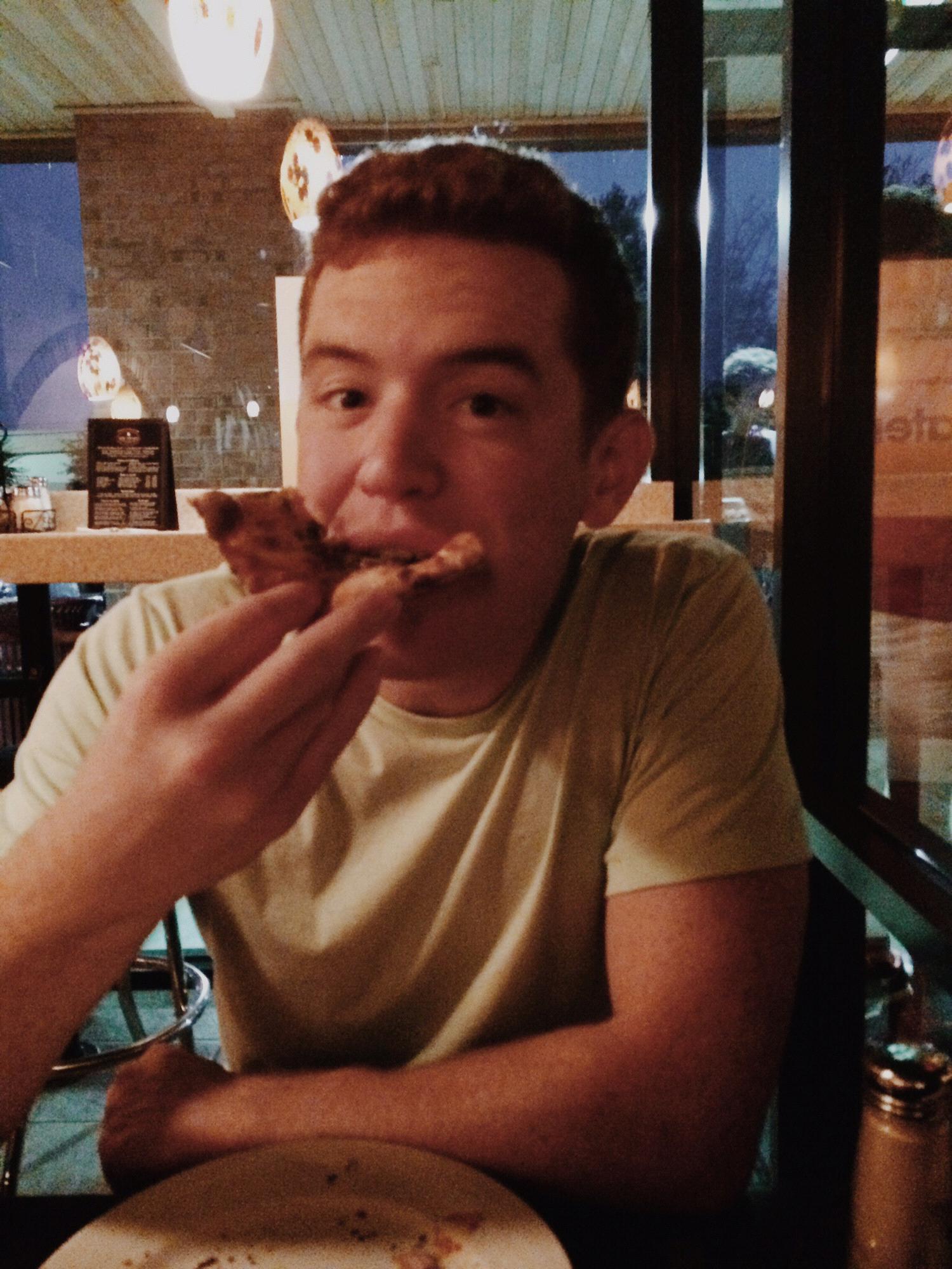 Travis enjoying some pizza.