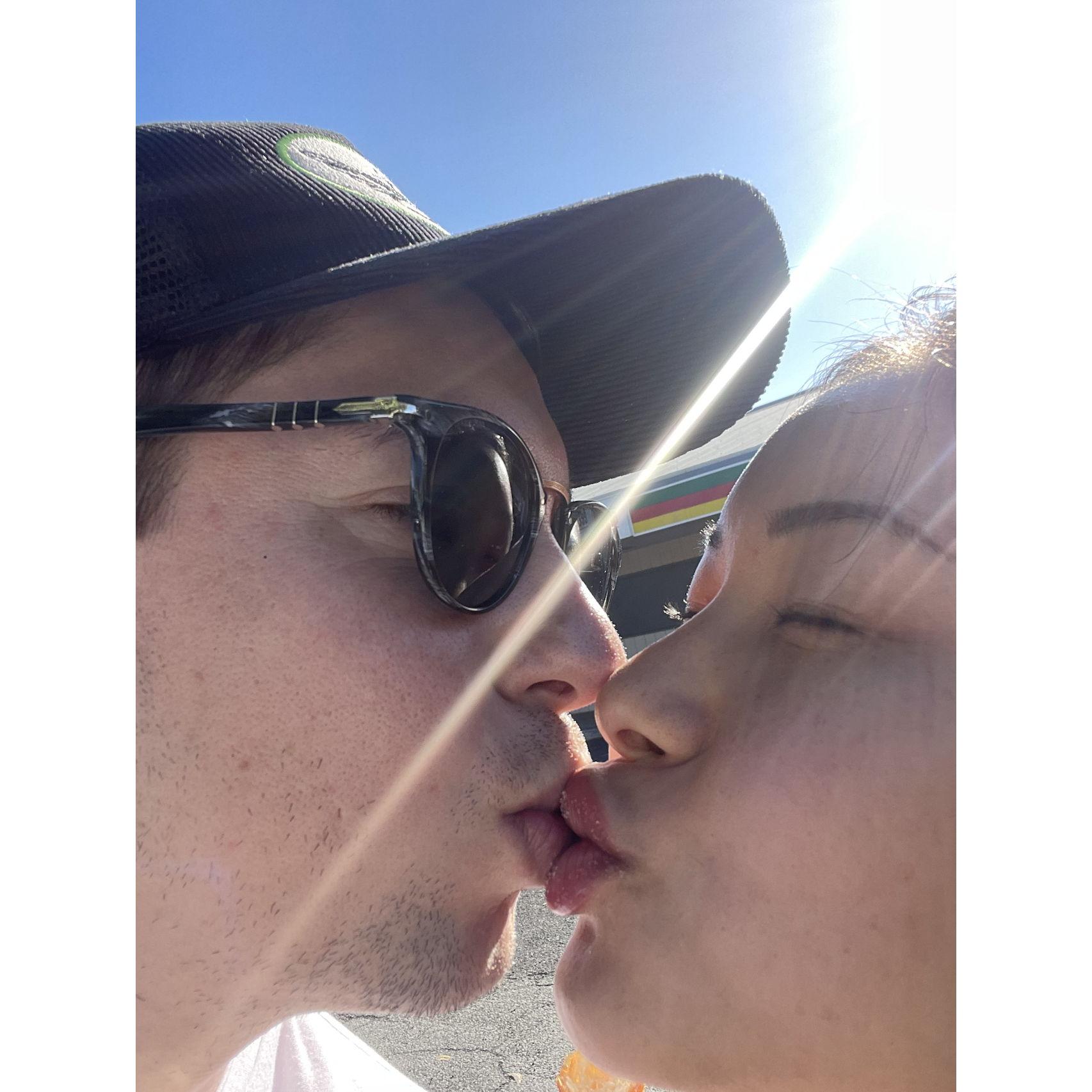 december 2022. sharing a sugar coated kiss after eating malasadas in Oahu during Christmas/New Years 2023