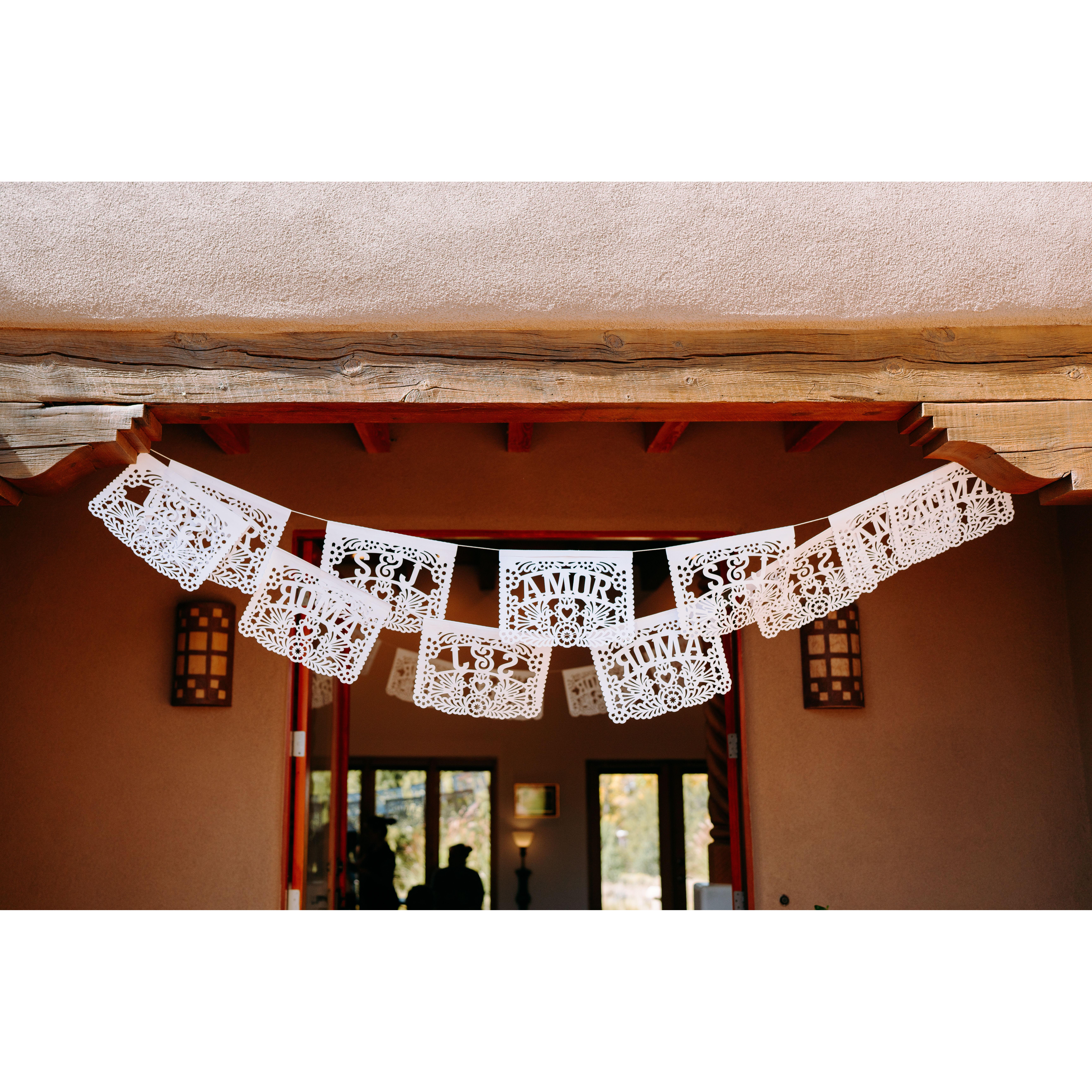 White papel picado flags are hung to symbolize a celebration