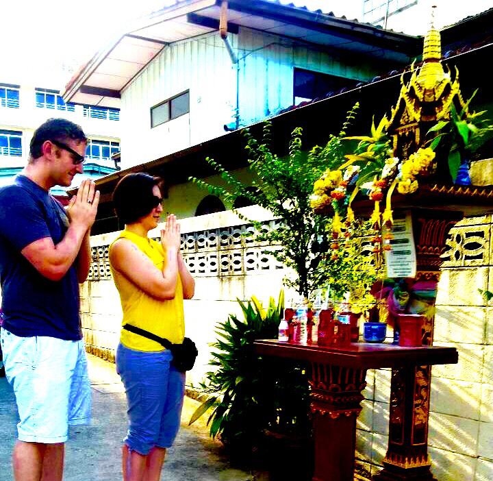 Paying respects to the spirit house in Thailand.