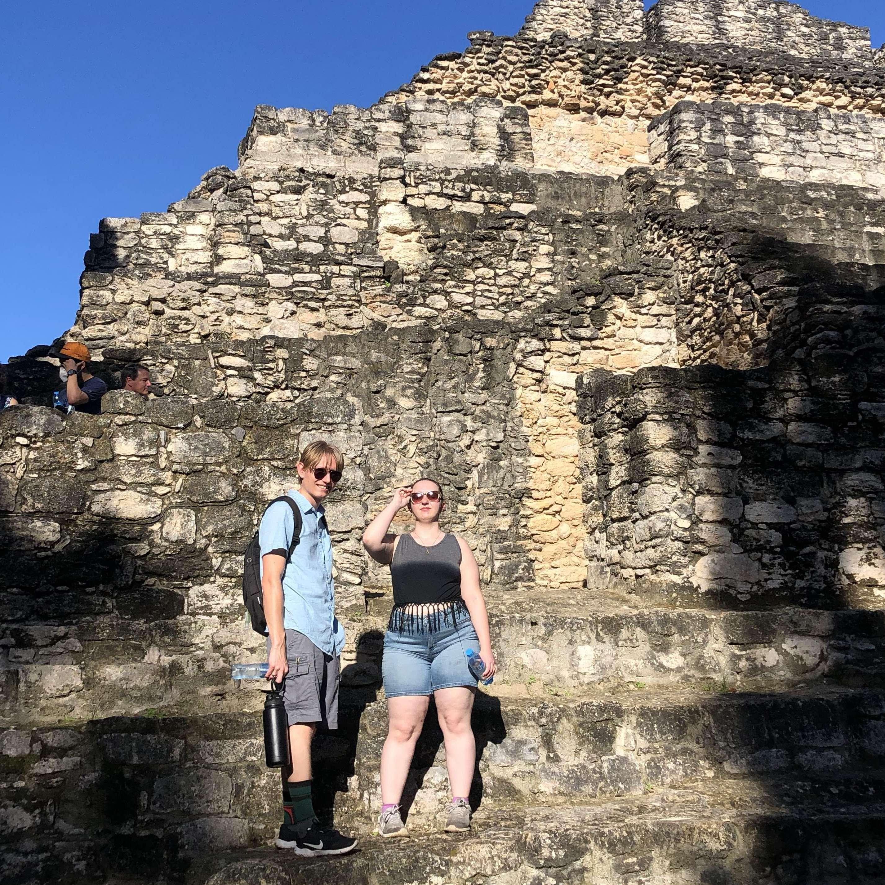 A couple of cool kids standing on a Mayan Ruin