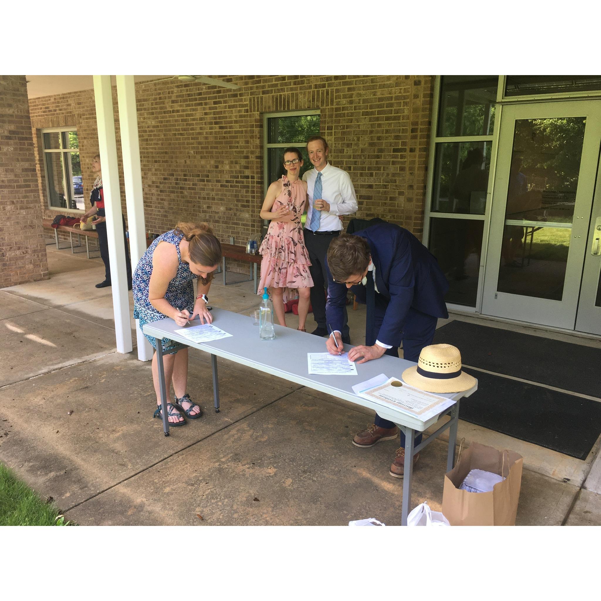 Bridesmaid Alanna and officiant Cameron work on our paperwork after the ceremony.