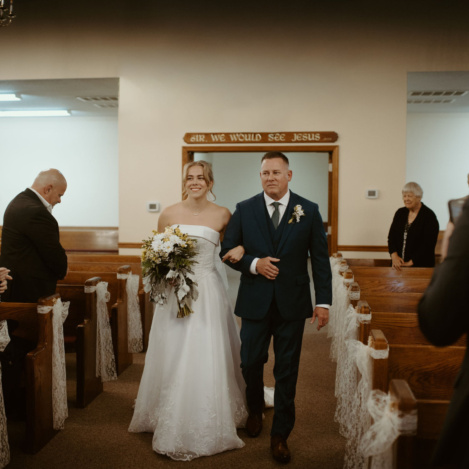 Mr. Tannar walking Leigh Anne down the aisle.