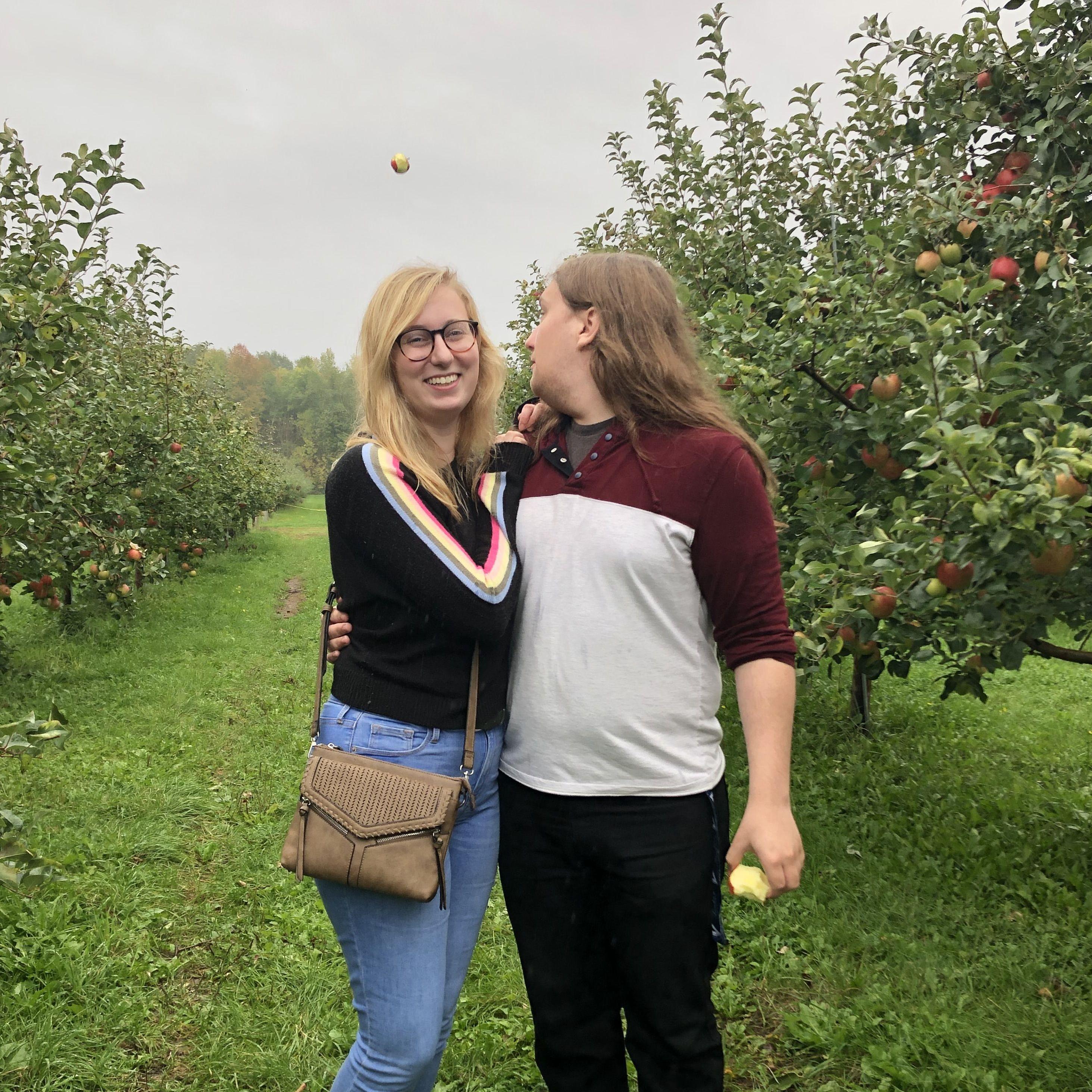 Trying to take a cute apple orchard picture, but your friend throws an apple over your head...