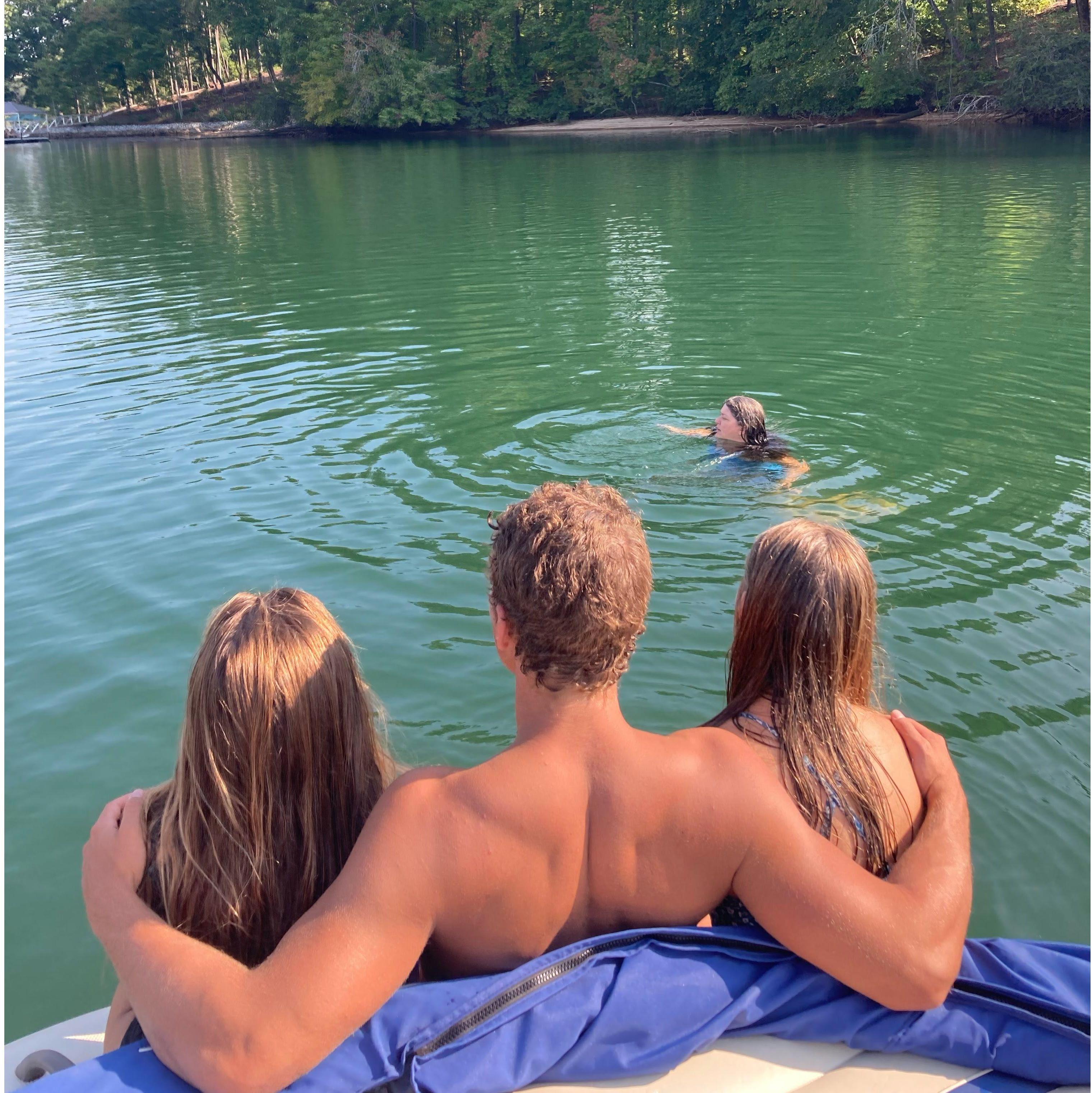 Trent, Madison, and Victoria relaxing on the edge of the boat