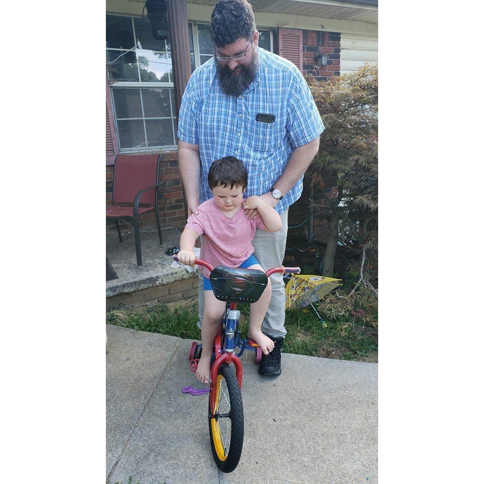 Kevin helping to teach Peyton to ride the new Superman bike we brought him.