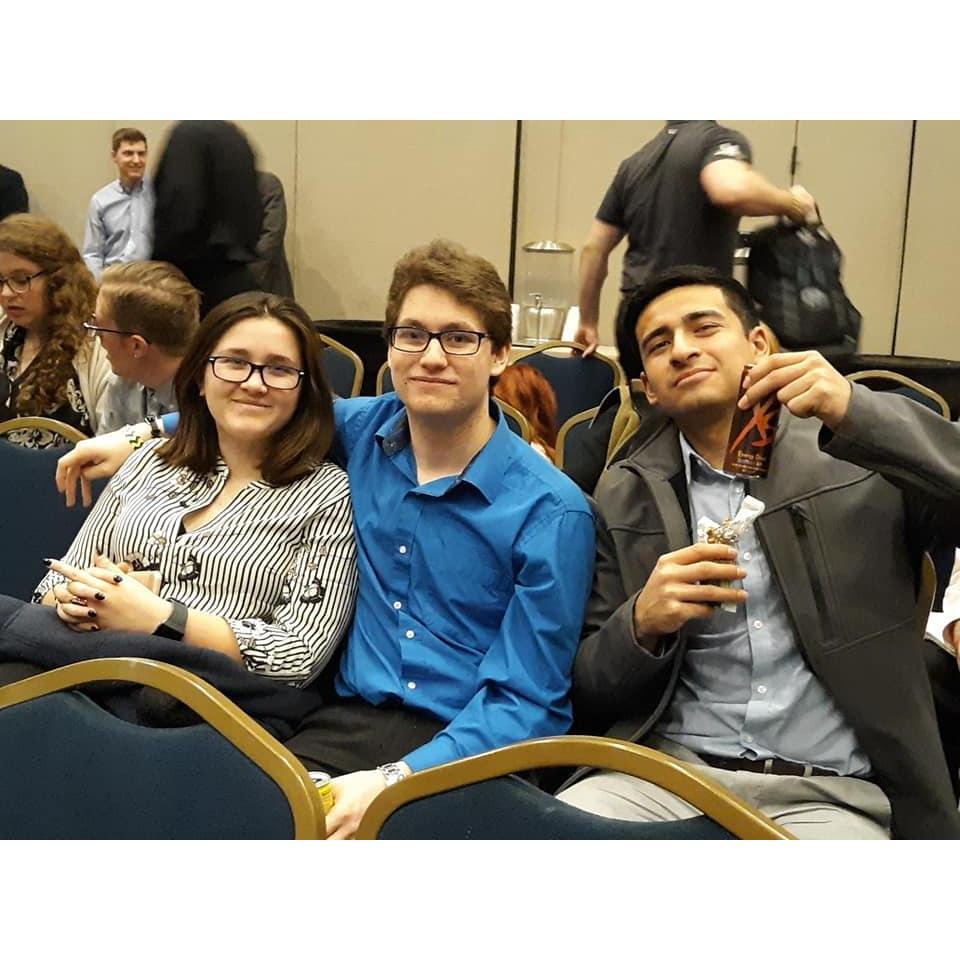 Krista, Ethan, and their business partner at a conference together.