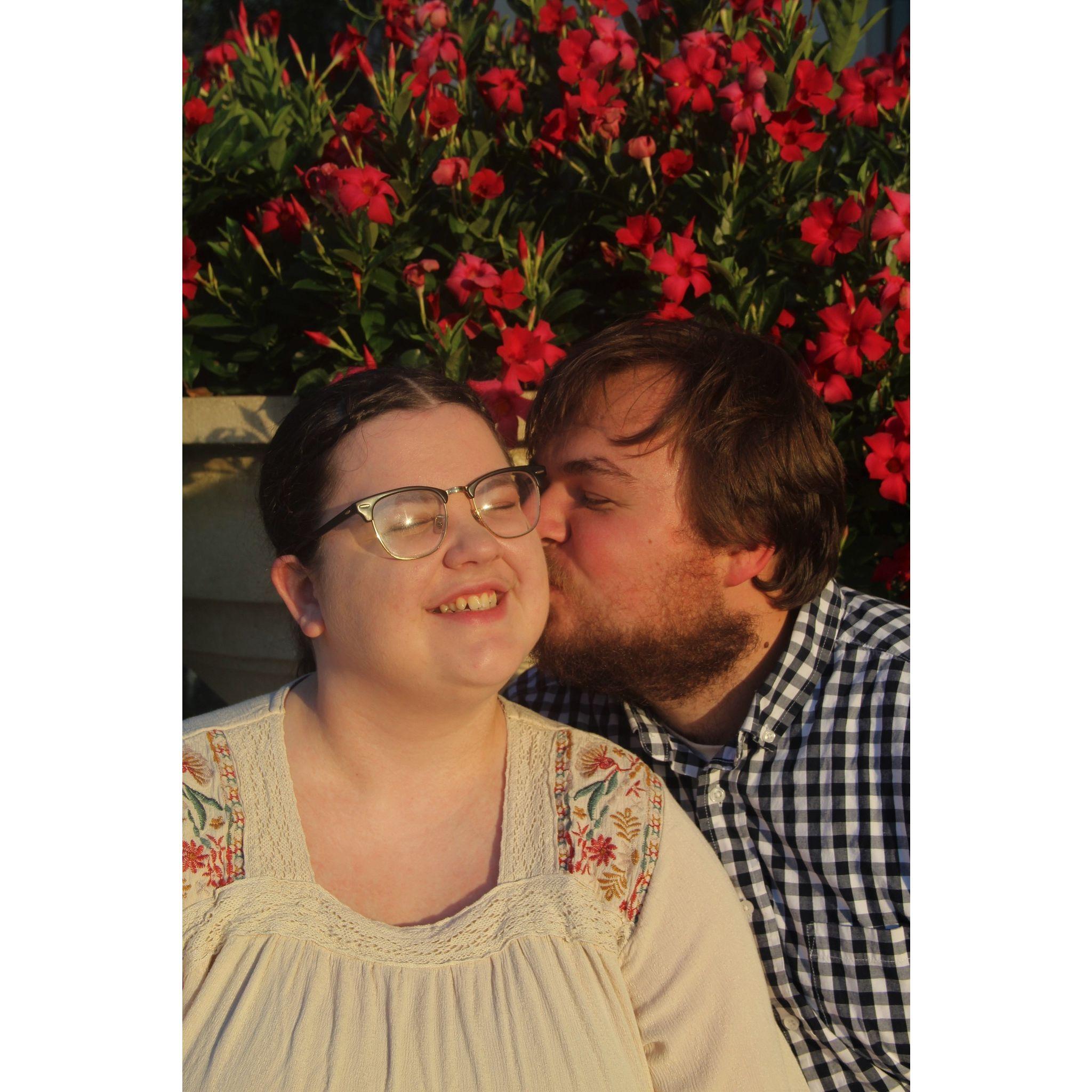 Sean and Madison sitting in front of a beautiful bush in Downtown Winter Garden, FL