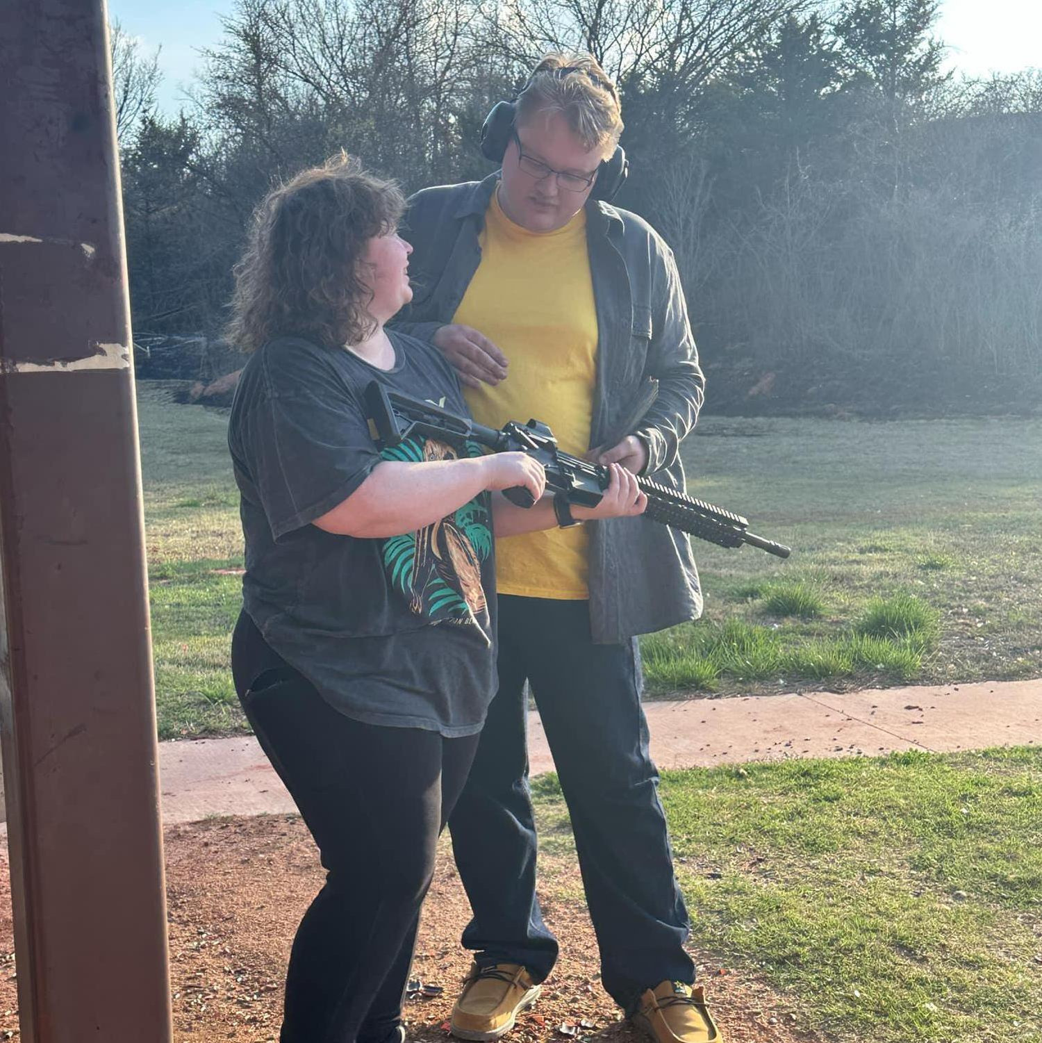 Derrick showing Catelyn how to shoot at the range