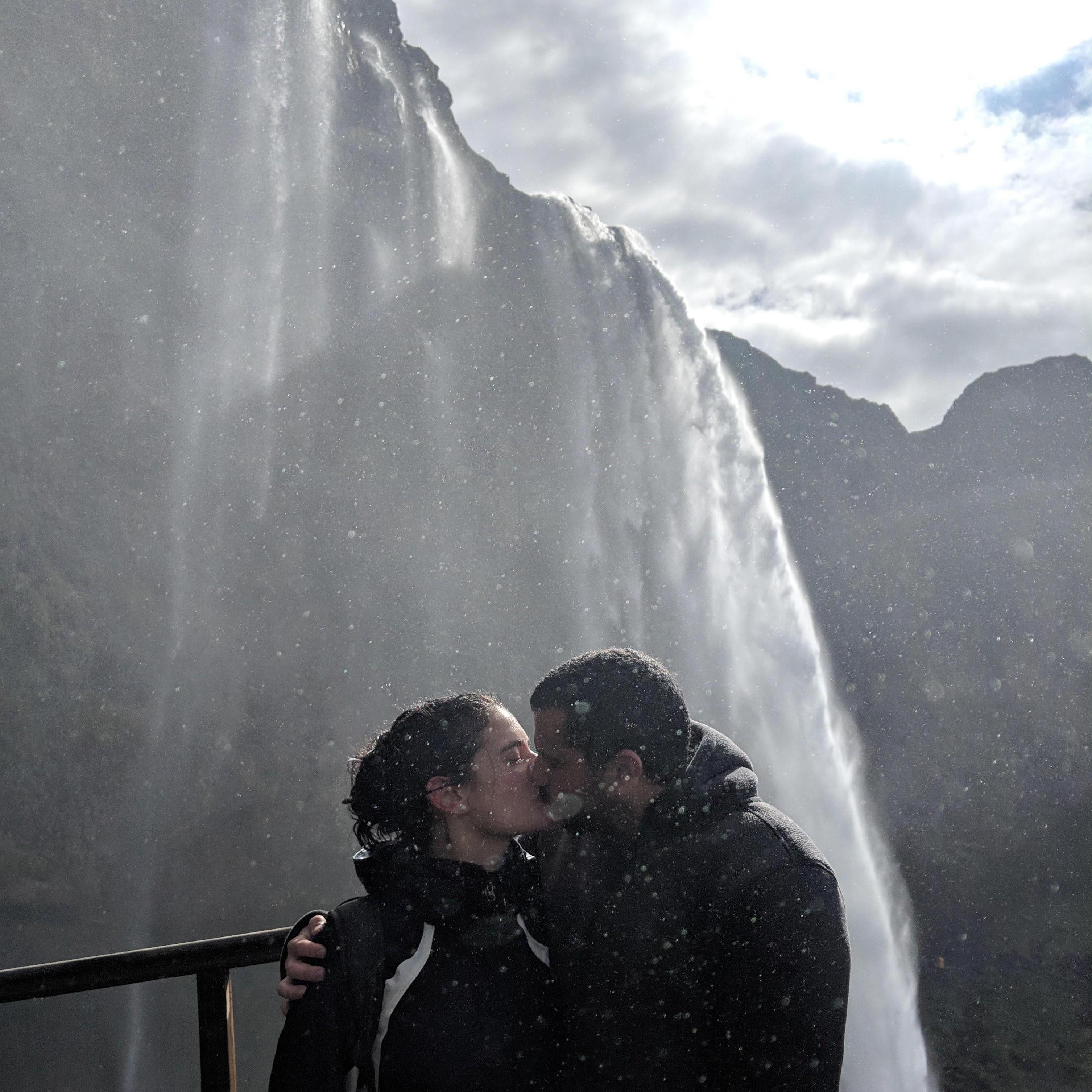 A kiss beneath a waterfall in Iceland.