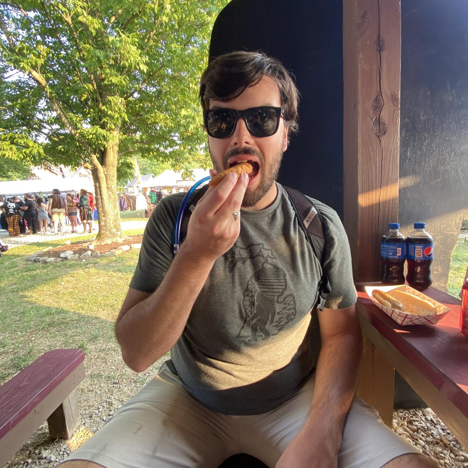Dalton eating a chicken tender off the ground after his sister, Haley, stepped on it on accident, Ohio Celtic Fest, June 2023