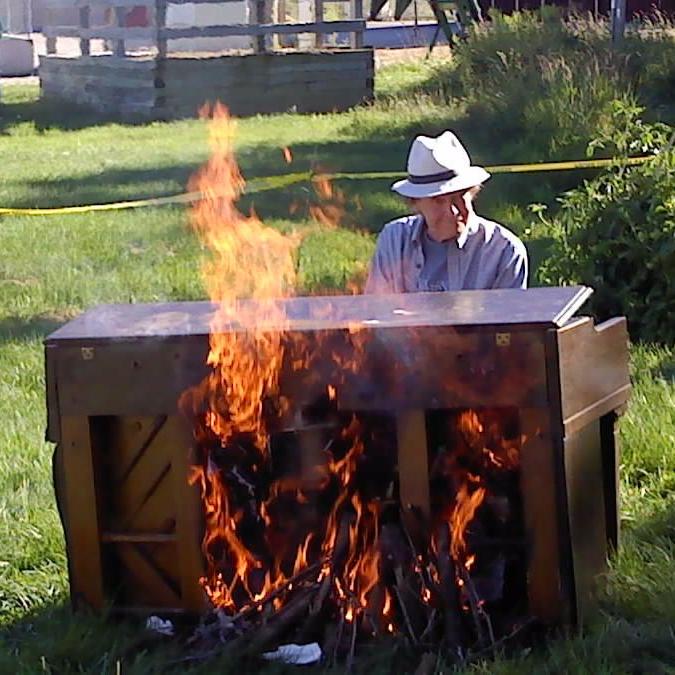 Our officiant, Rev. Larry Collins, playing the flaming piano at the culmination of the summer solstice celebration of the former Roxbury Tavern.