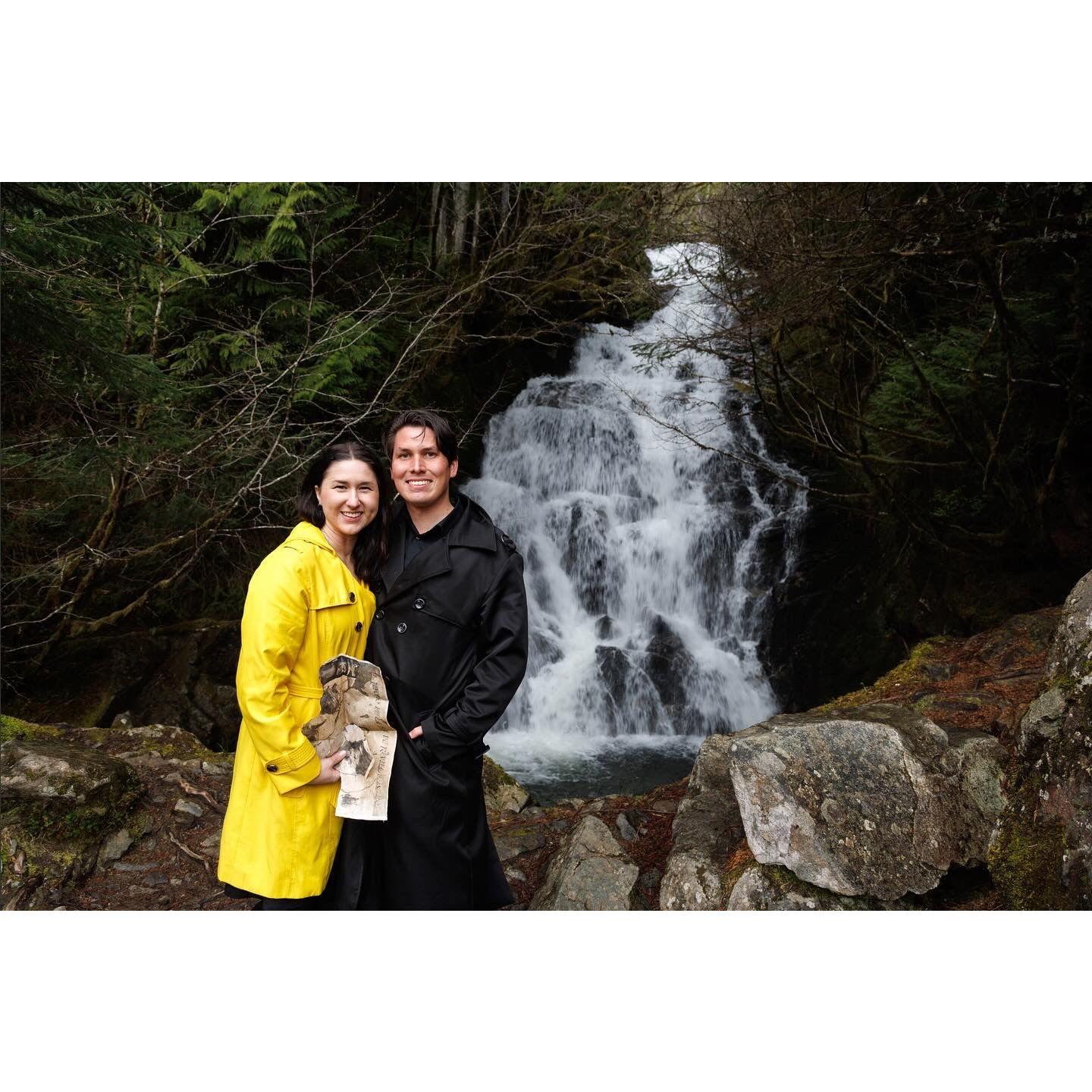 At the waterfall where Christopher proposed. Alissa is holding the treasure map that he created for their Indiana Jones-themed scavenger hunt