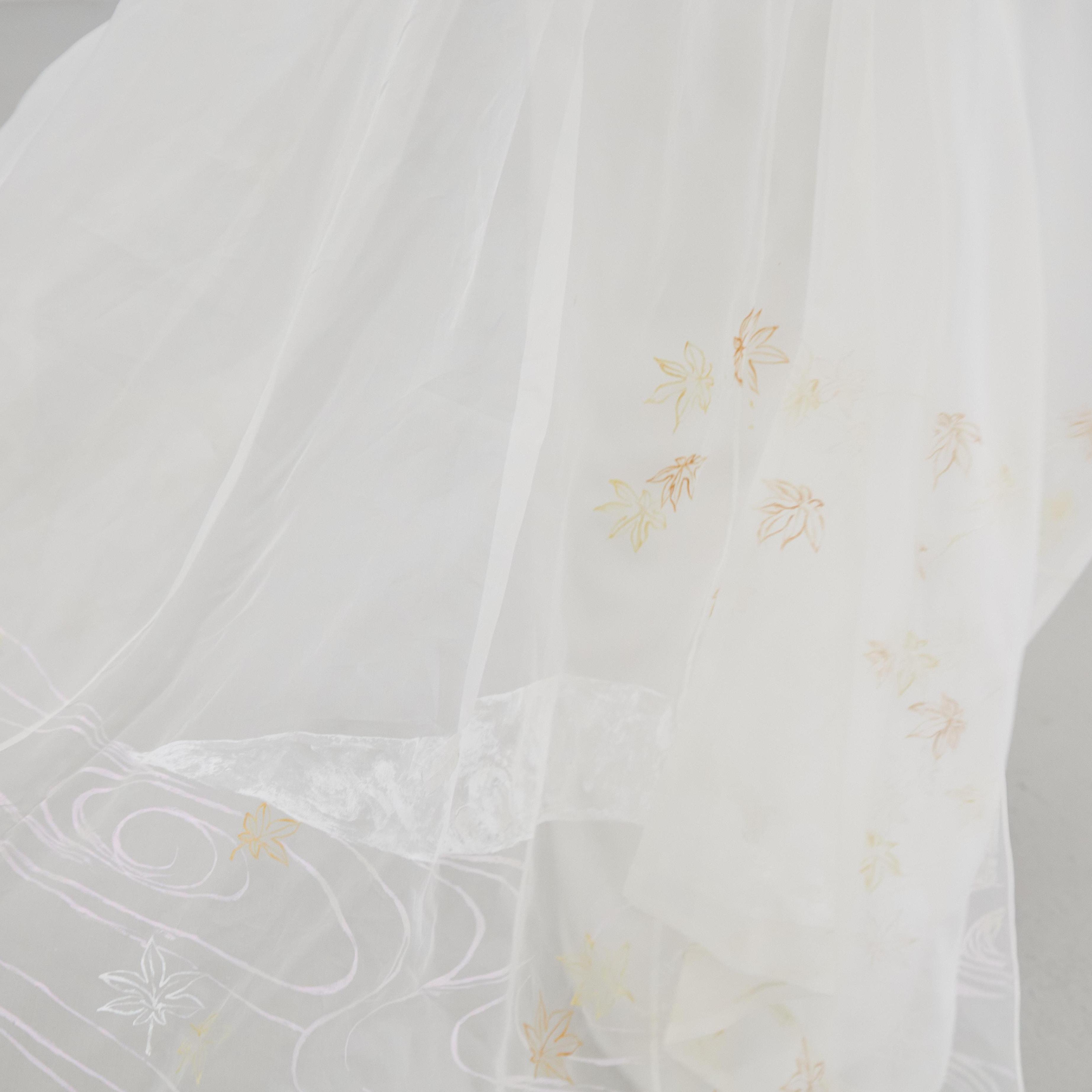 Close-up detail of the wedding cape, featuring hand-painted autumn motifs by Cleo's mother, Misuzu.