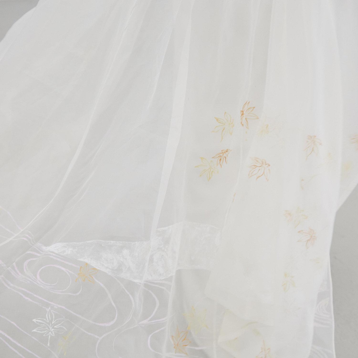 Close-up detail of the wedding cape, featuring hand-painted autumn motifs by Cleo's mother, Misuzu.