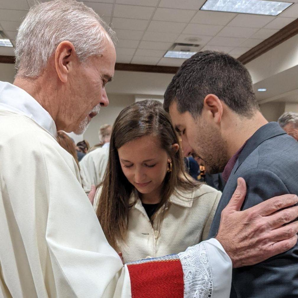 Deacon Phil Bodman (Dillon's host in OKC) prays with the newly engaged couple after his ordination