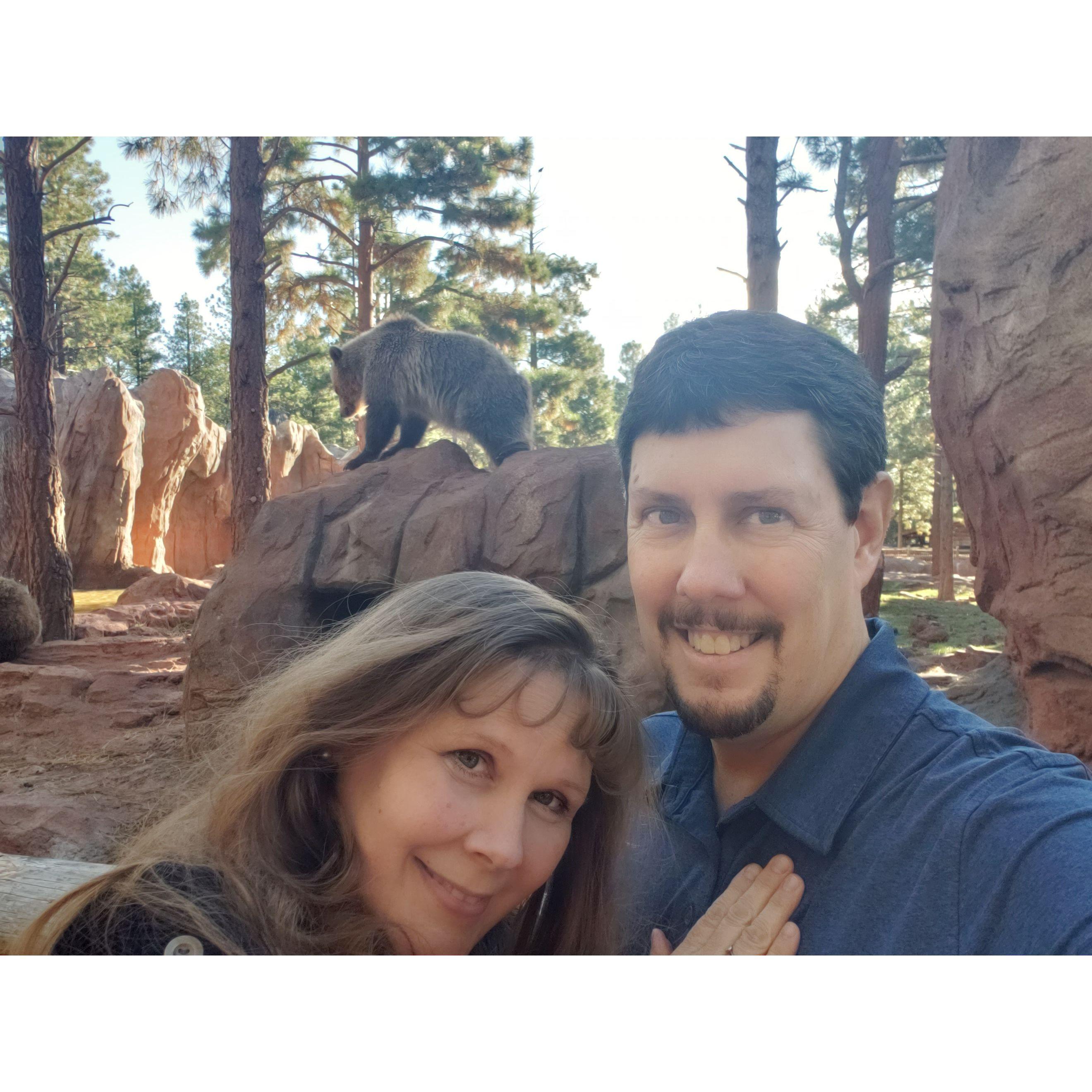 Lori and John with a grizzly bear at Bearizona - a wildlife experience in Northern AZ.