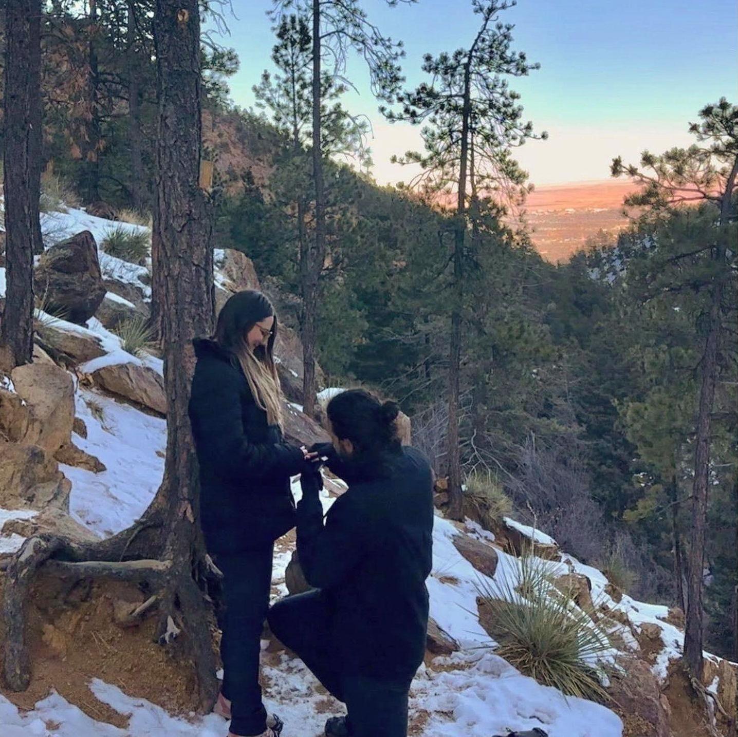 Juan proposing to Lindsey with a beautiful view overlooking Colorado Springs.