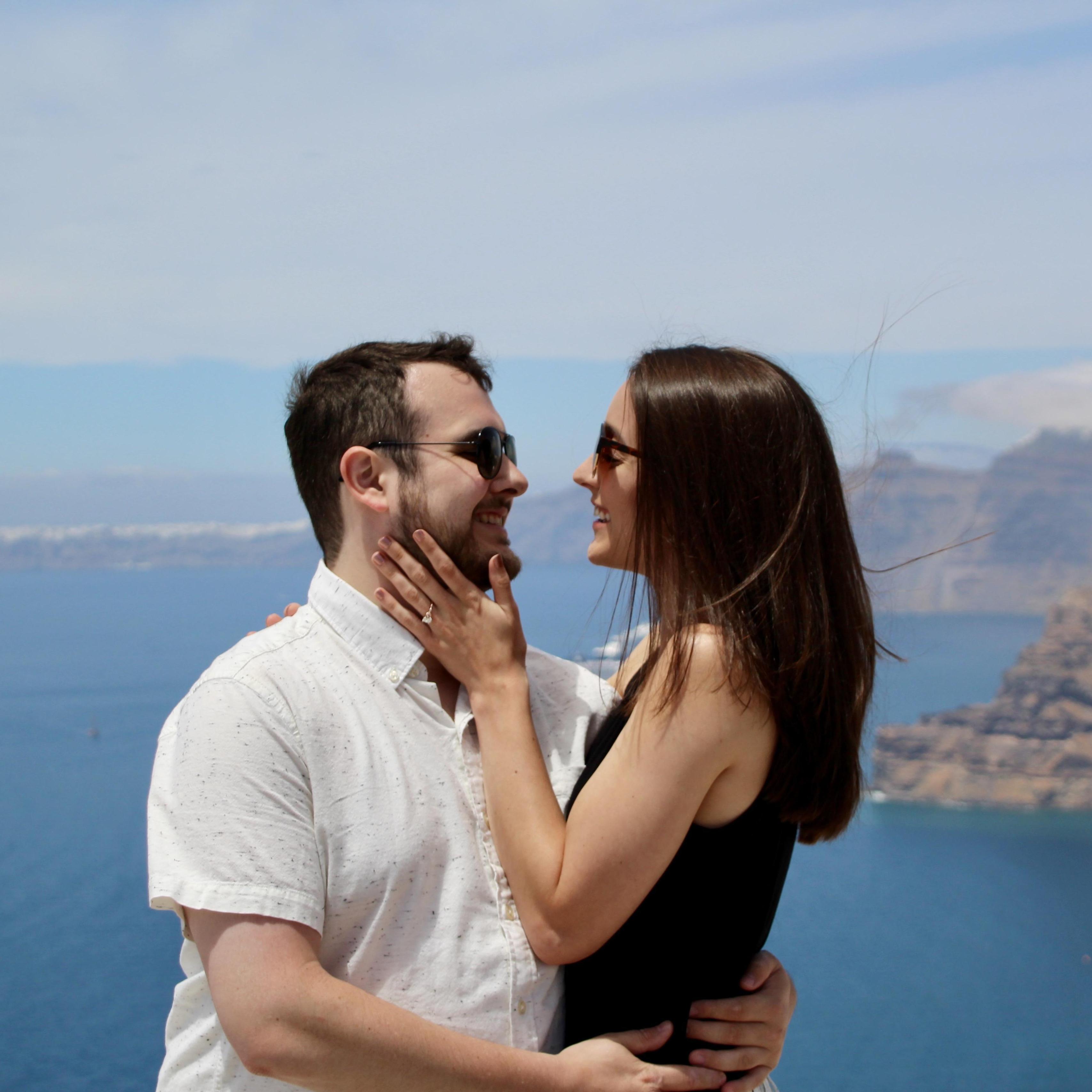 Newly engaged and standing above the Caldera of Island of Ancient Thera. Commonly known today by the Venetian name, Santorini.