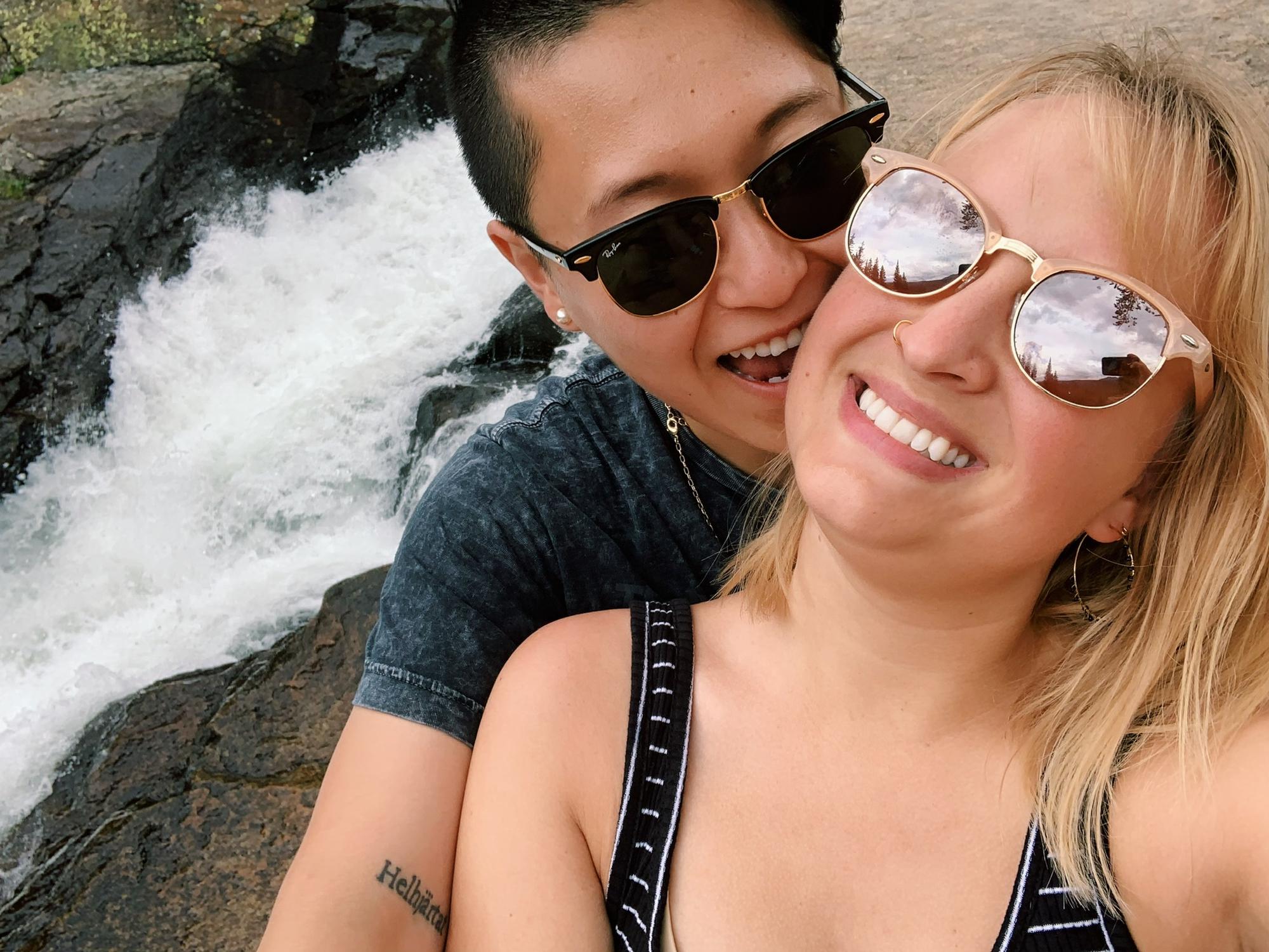 Our first trip together to Colorado in 2019! Picture description: A selfie of Anhthu and Ashley on rocks in front of a running waterfall.