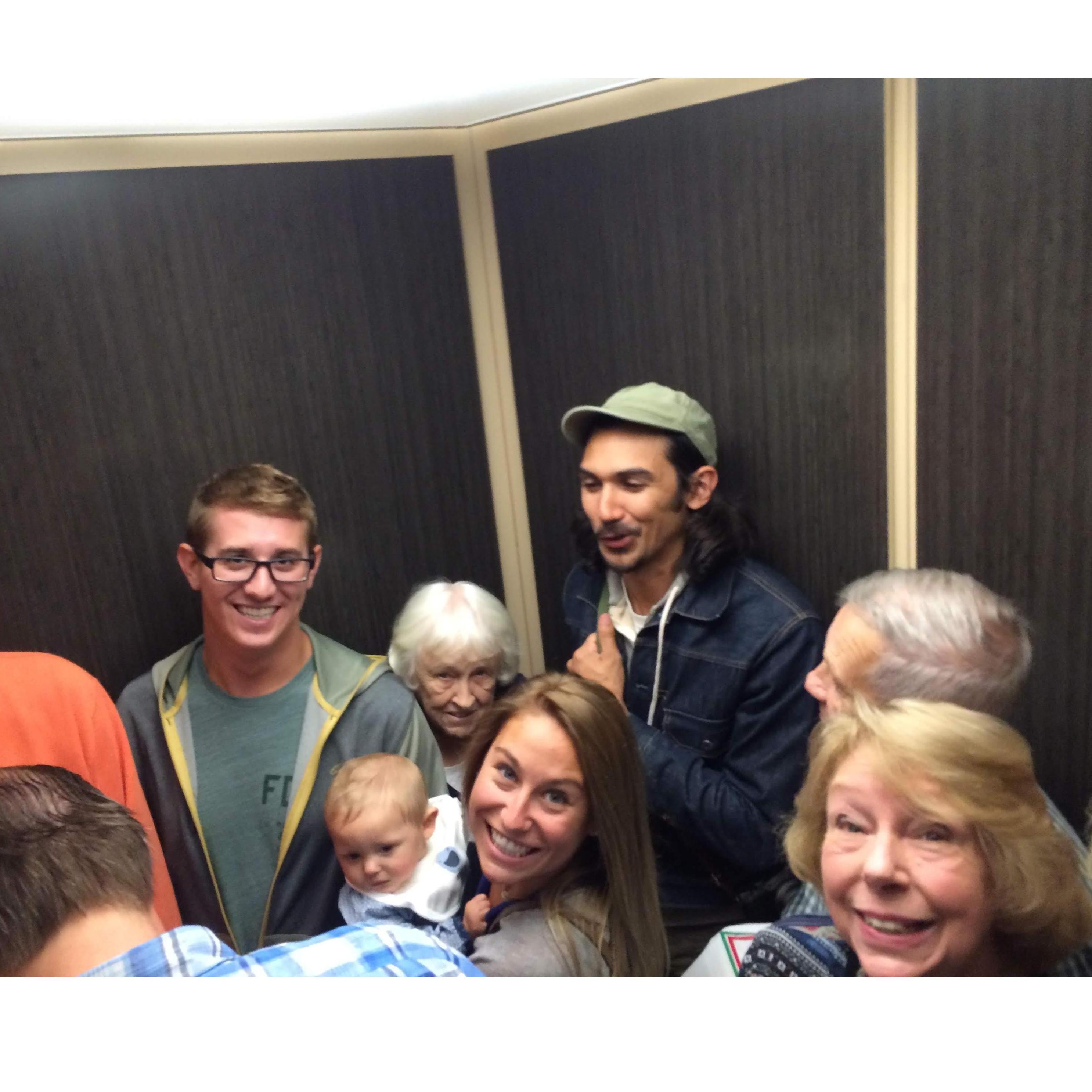 Nikos in a crowded elevator of Chelsea's family