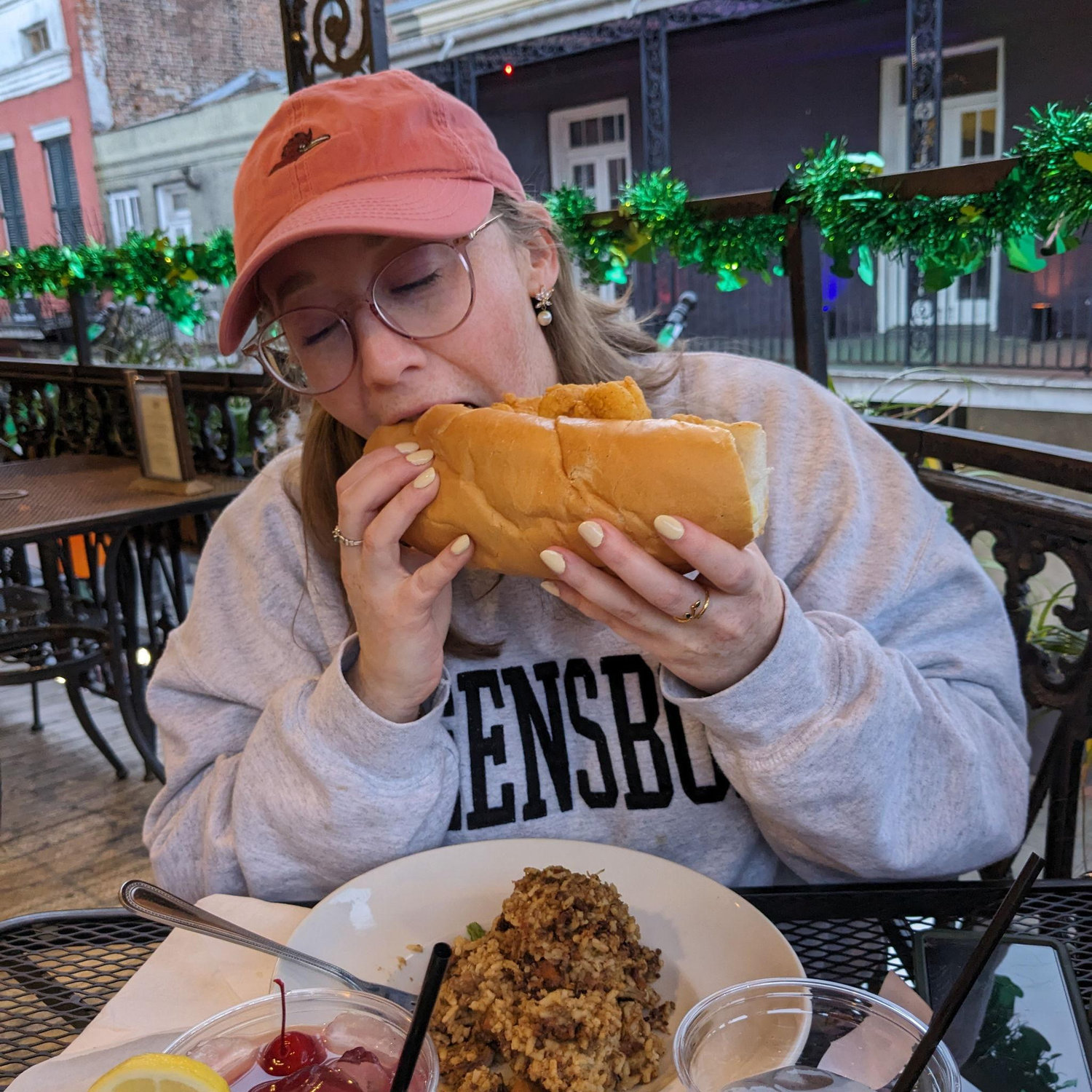 Emily taking a big bite of a poboy that Jack offered