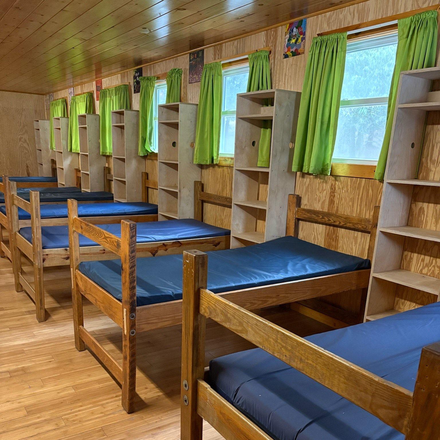Camp Saginaw Cabin - has Wooden beds that can be moved around, bedding will be provided. Each bed has shelving and an outlet next to it.