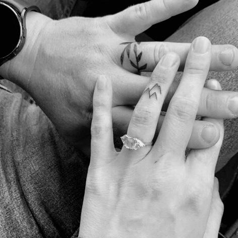 Our tattoos on our ring fingers. His of Laurels, Hers of Cliffs