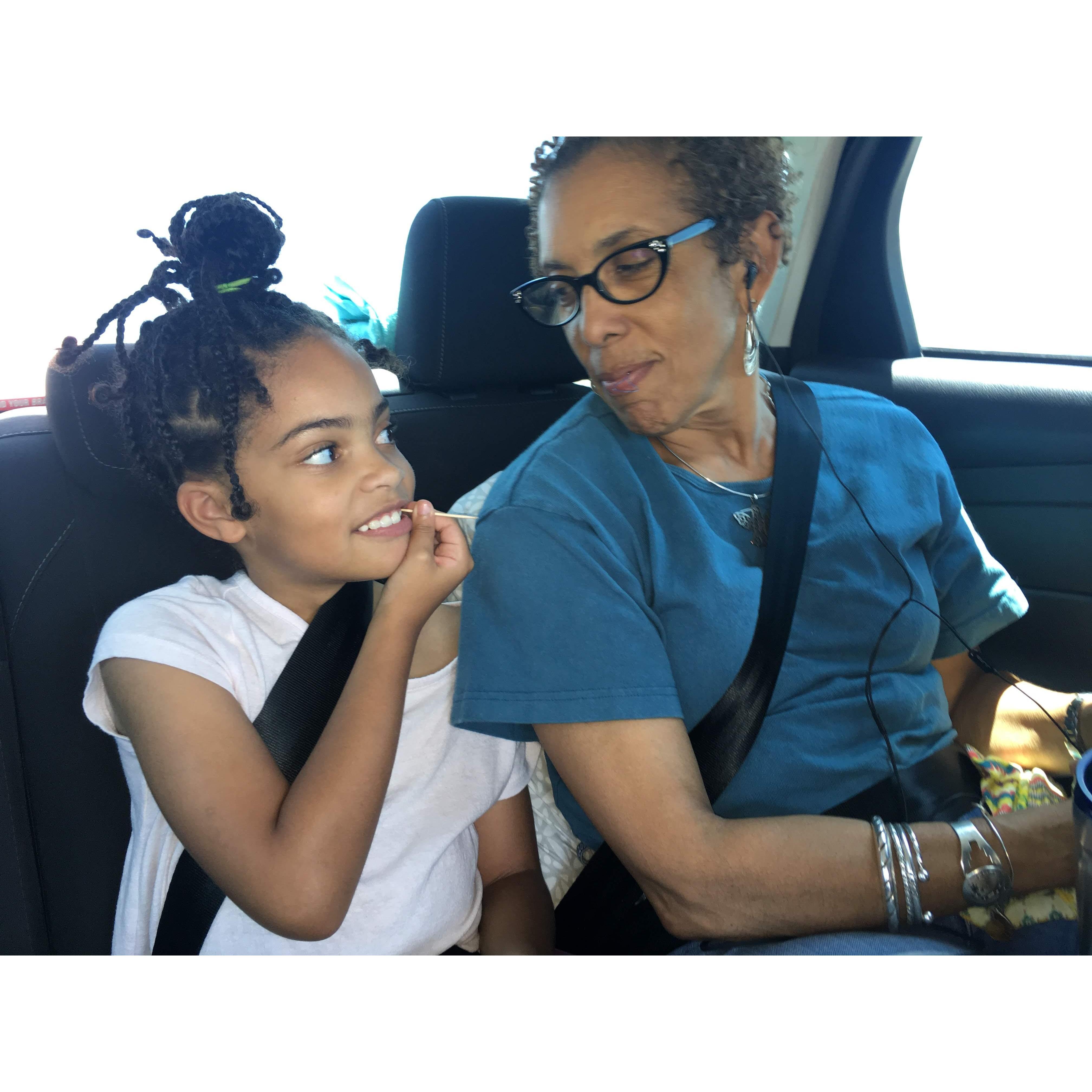 Layla and Mae exchanging knowing looks. A penny toss would determine who called who "Ms. Daisy." (En route to Albuquerque, July 2019)