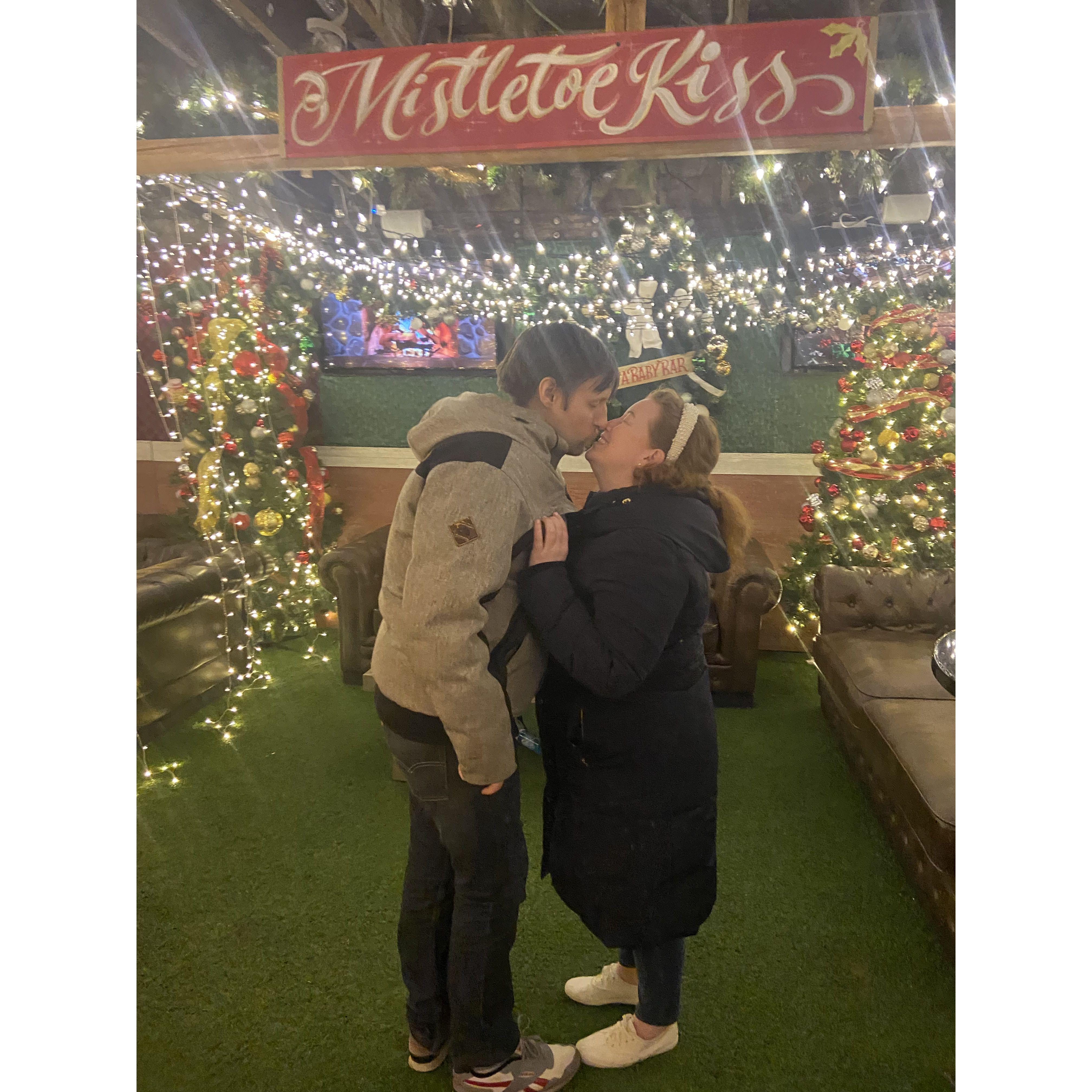 Kissing under the mistletoe at Dueces in Wrigley. Chicago, December 2022.