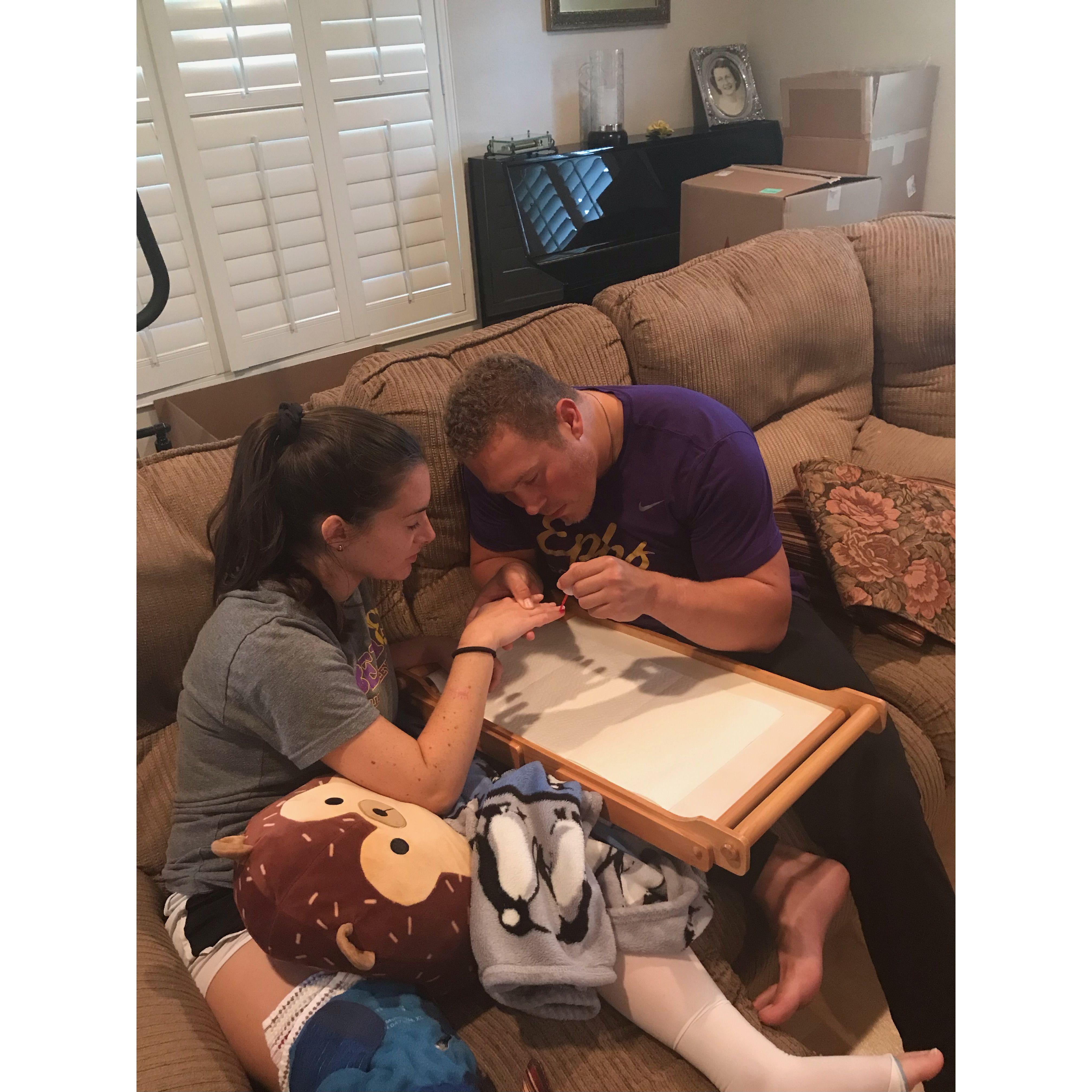 Kyle attempting to paint Allison's nails after surgery
