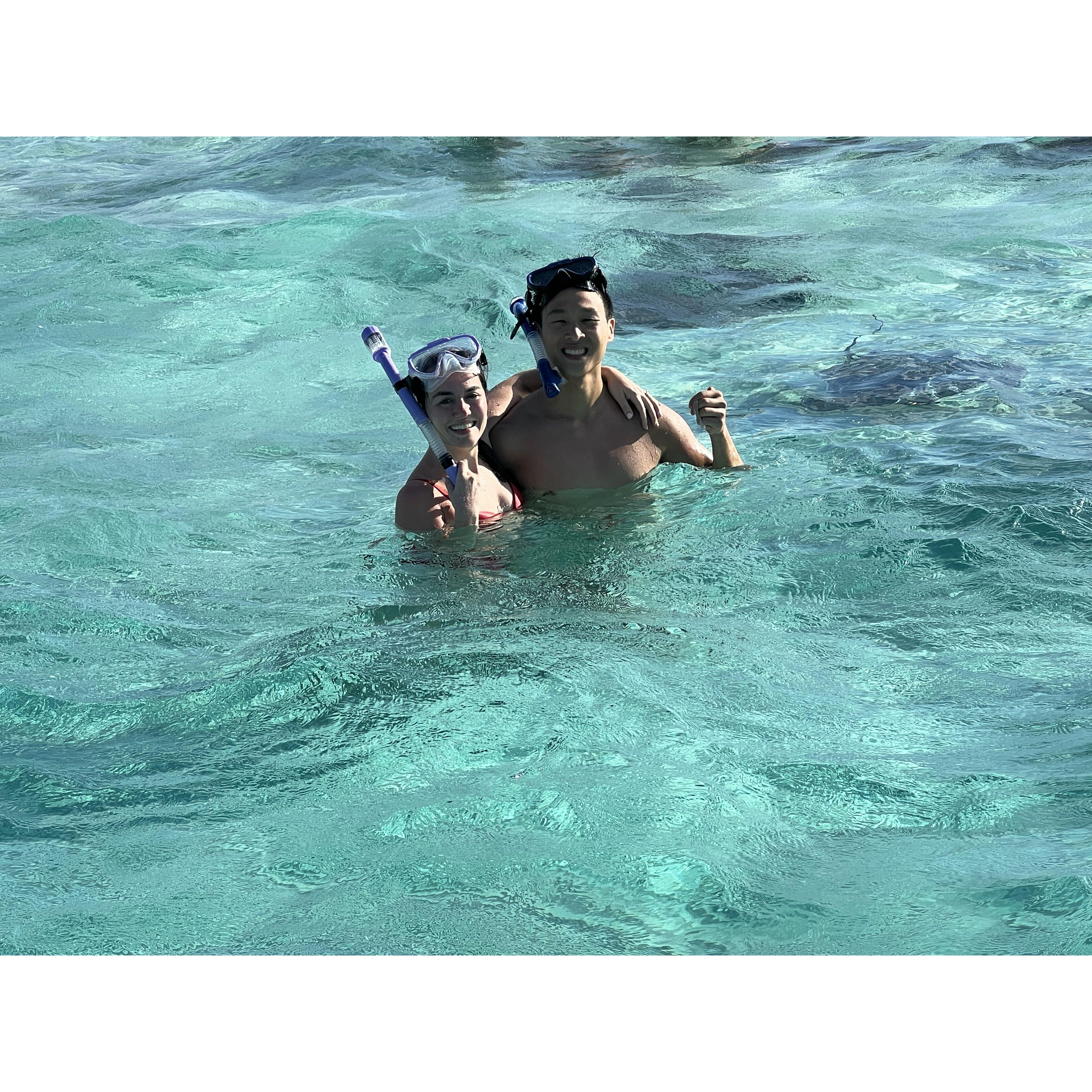 Swimming with the stingrays during their engagement trip to the Cayman Islands