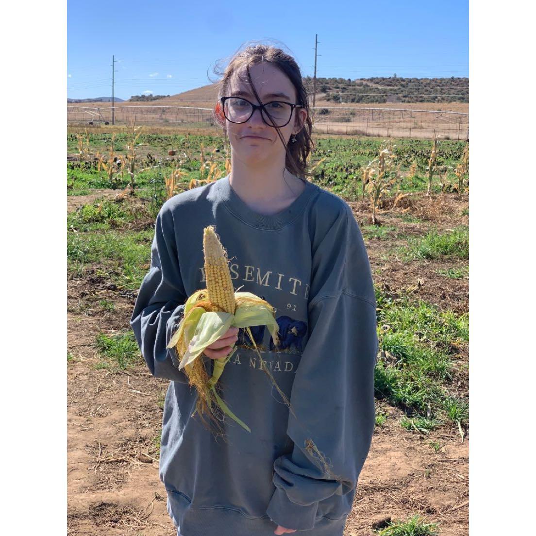 went on a trip with our friends, while my friend got a flower from her bf. He gave me and ear of corn. This was the photo he took of me after.