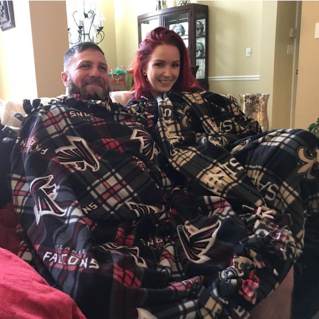 Falcons fan and a Saints fan sharing the same blanket!