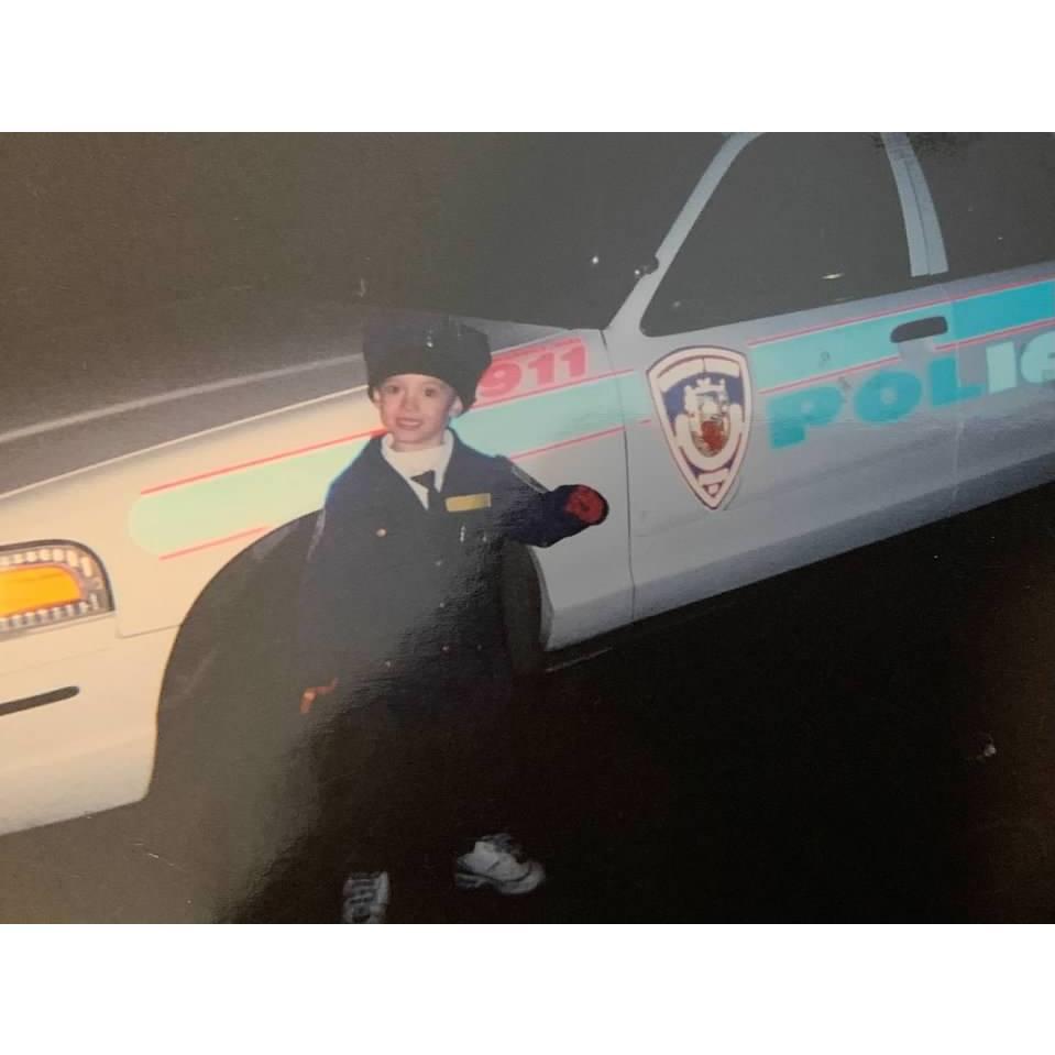 Austin as a child dressed up as a police officer