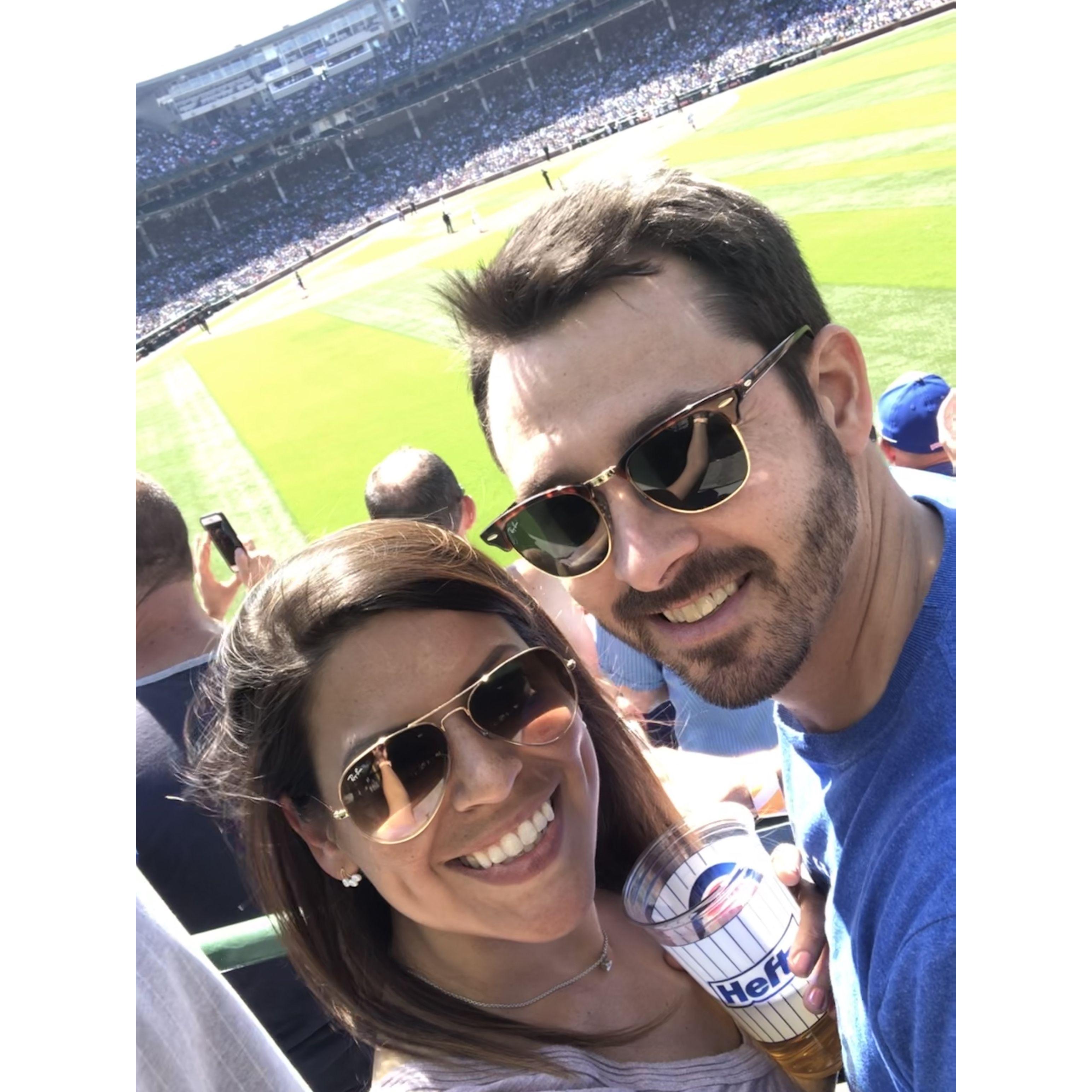 August 2019: Enjoying a Cubs game (because the stadium is fun, not because we love the Cubs GO WHITE SOX). Ed won Erika over the day prior by cooking her a salmon dinner.