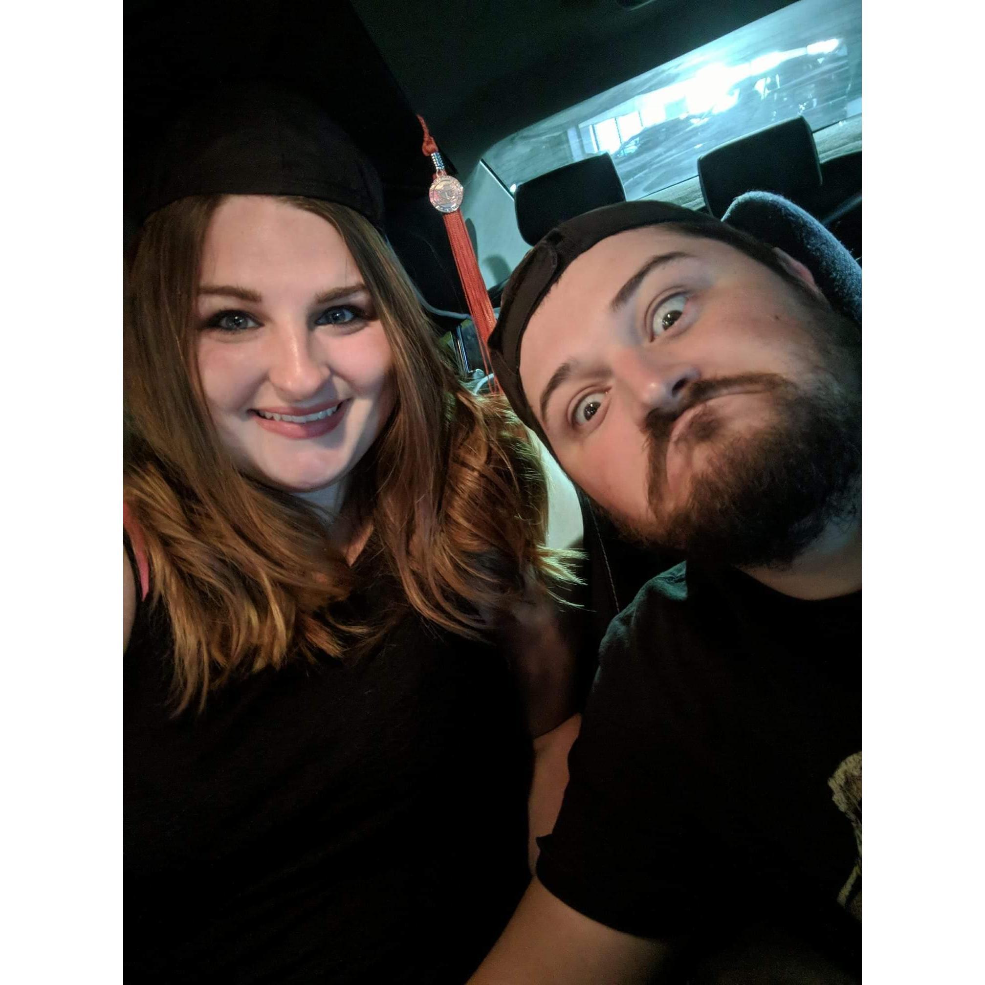 Goofy man supporting his girl on the day she graduated college.