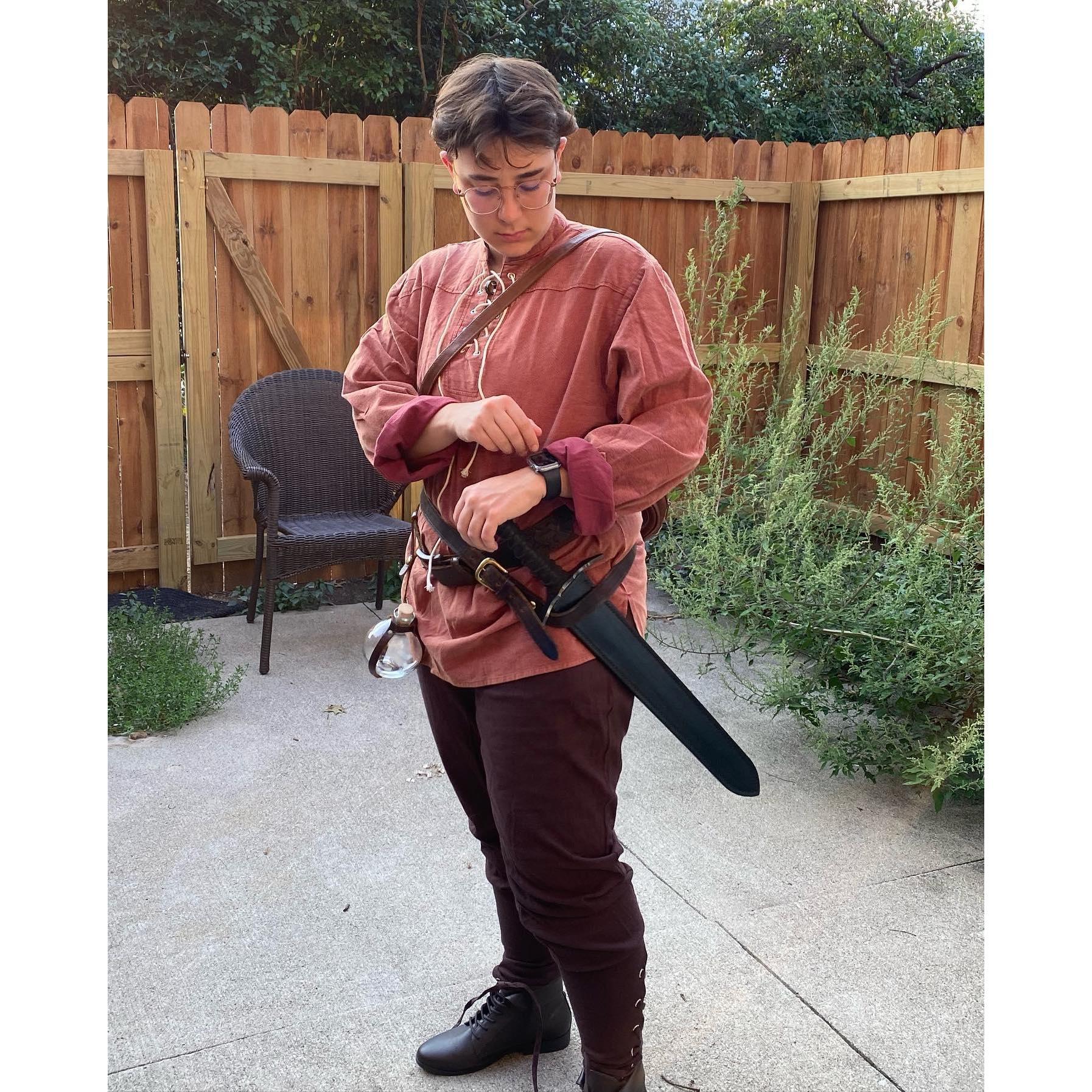 Emily is dressed as a fighter with a tunic, leather boots, sword, and potion bottle (The apple watch is not necessarily to theme but does keep the time well!)