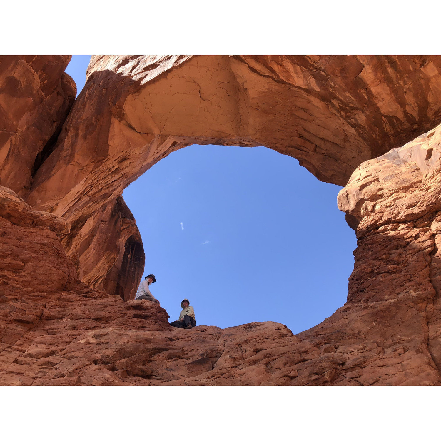 Perched in Double Arch on a trip to Arches National Park, Utah to climb and hike and explore together.