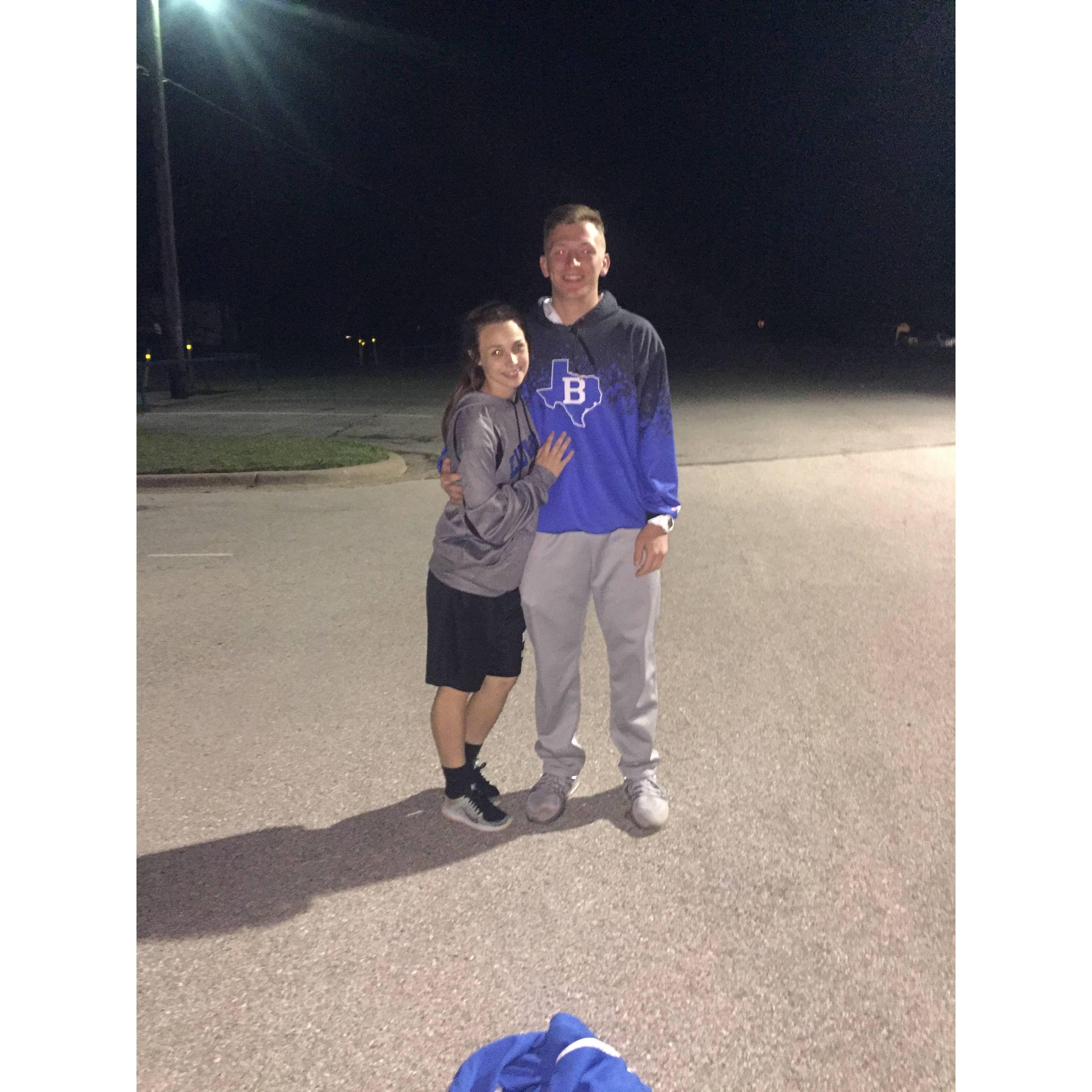 After a high school track meet in the school parking lot.