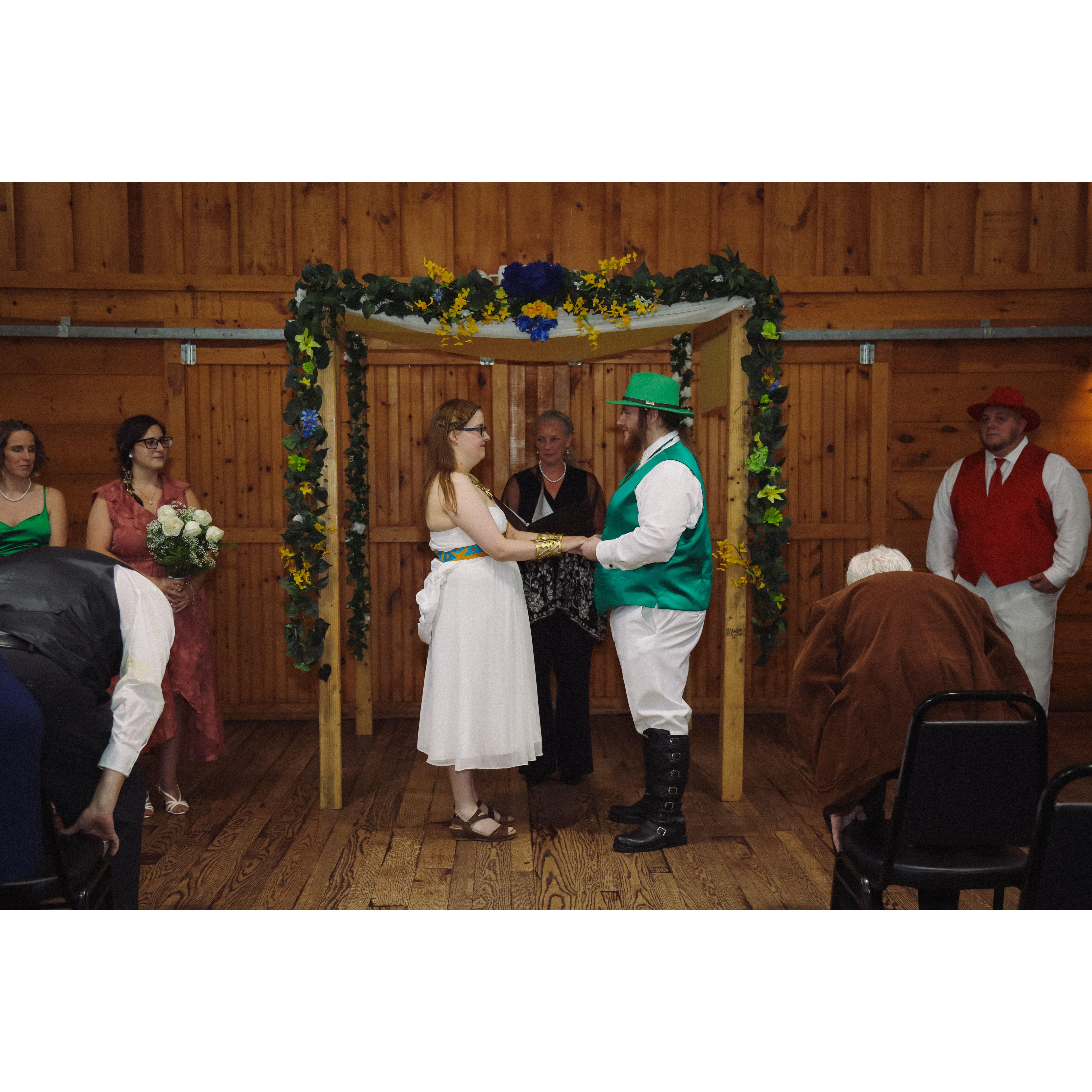 during the ceremony, Sara and Herb holding hands under the arch with the officiant