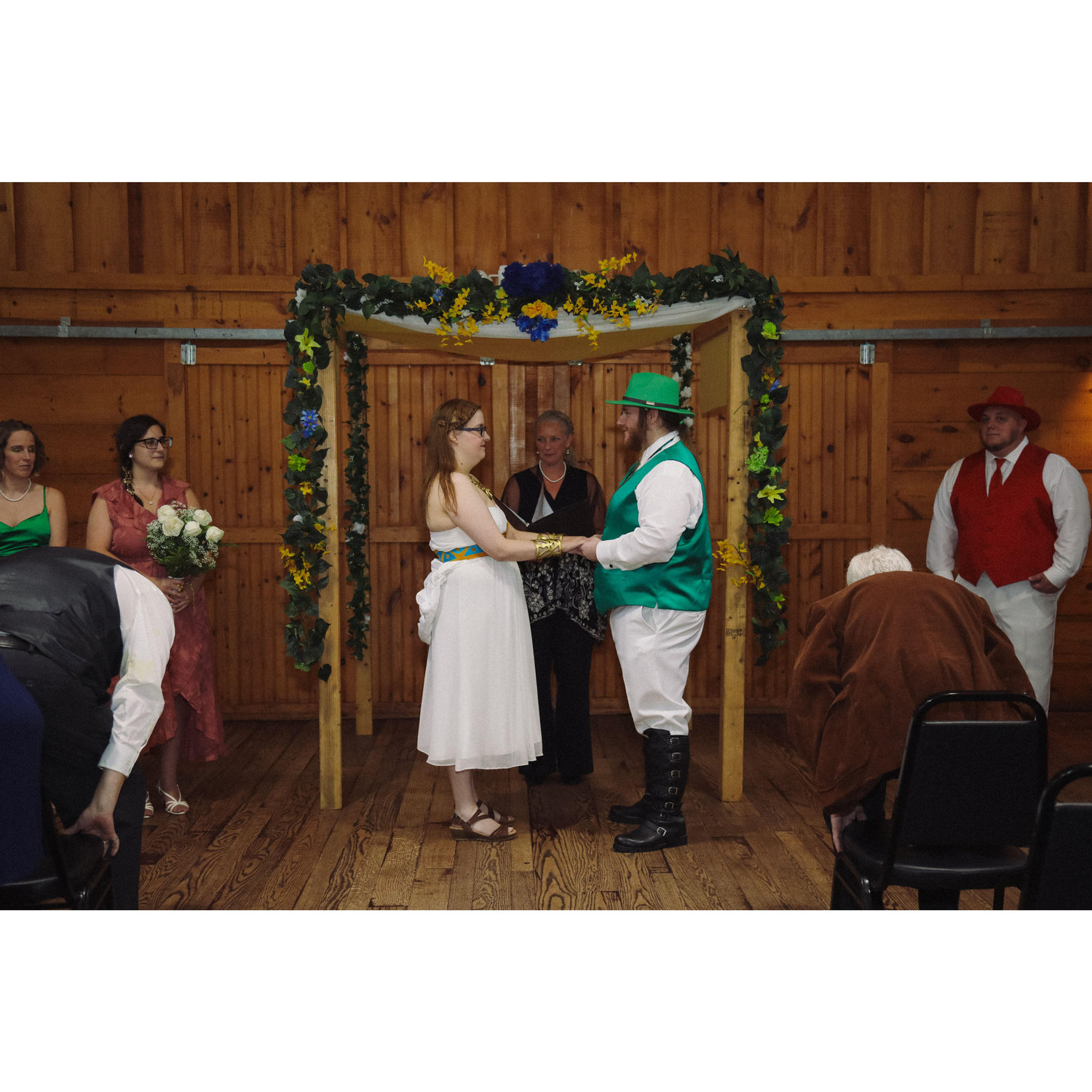 during the ceremony, Sara and Herb holding hands under the arch with the officiant