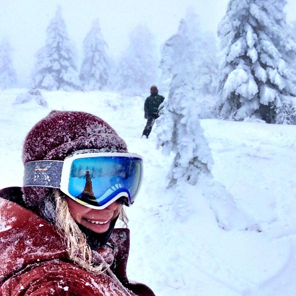 Matt hiding behind a snowy tree ready for takeoff, at Bogus Basin.