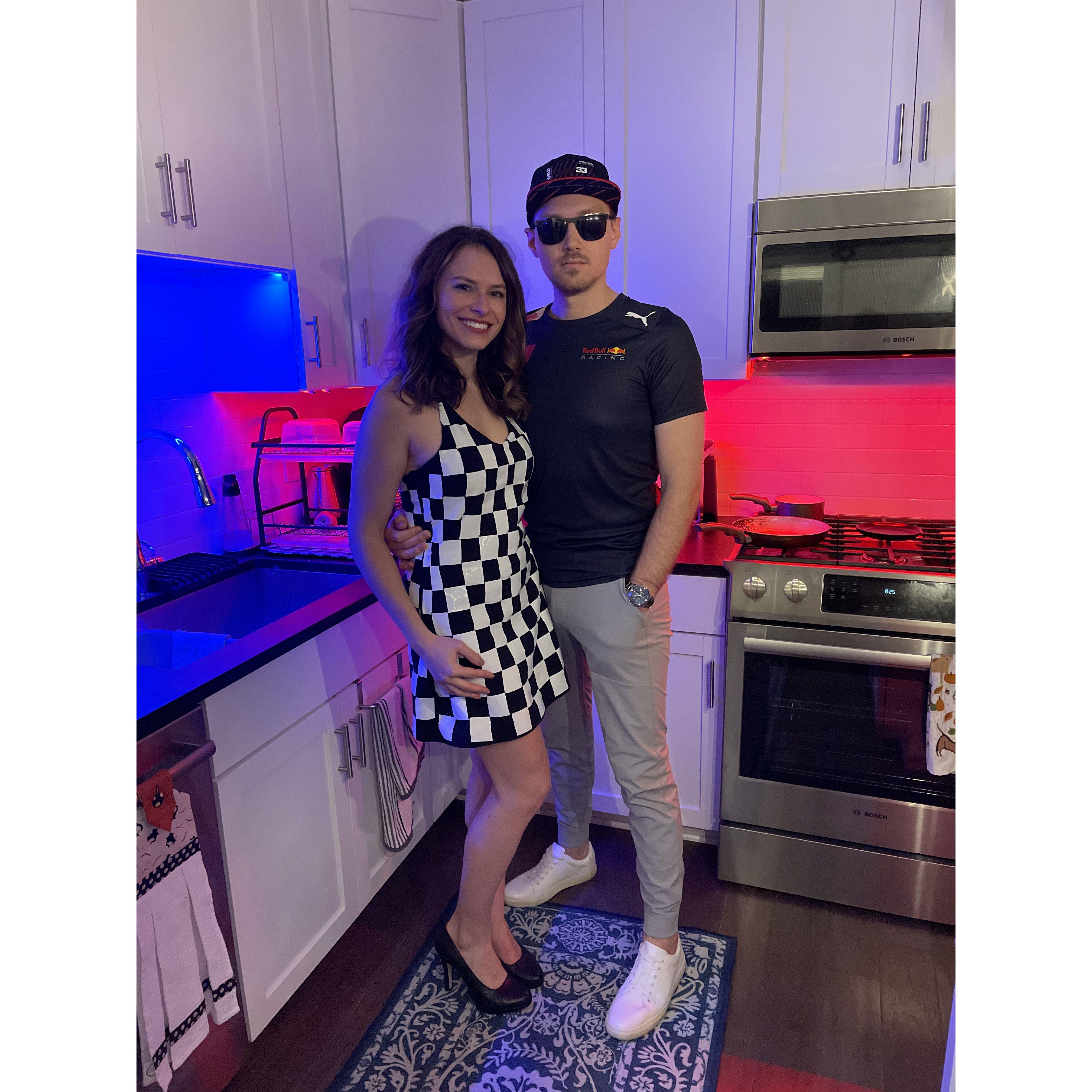 Their first couple's costume as Max Verstappen (F1 driver) and the black & white chequered flag.