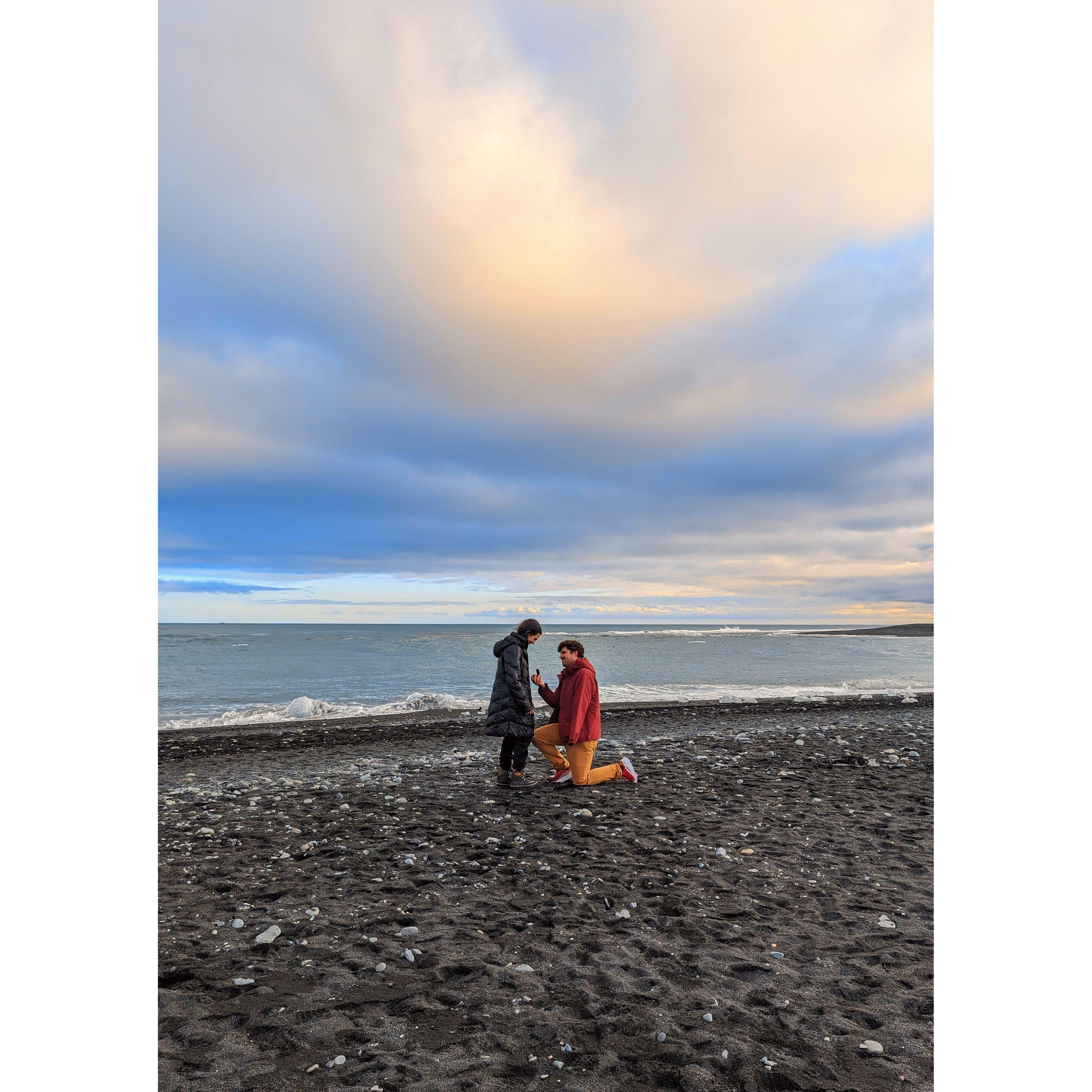 Engaged on a black sand beach in Iceland, 2024