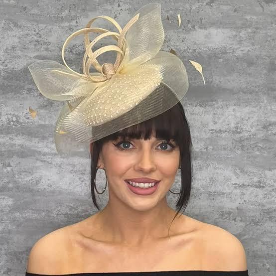 This is a fascinator. Women in the UK typically wear them to weddings. It’s completely optional, but all are welcome to join in on the fun!