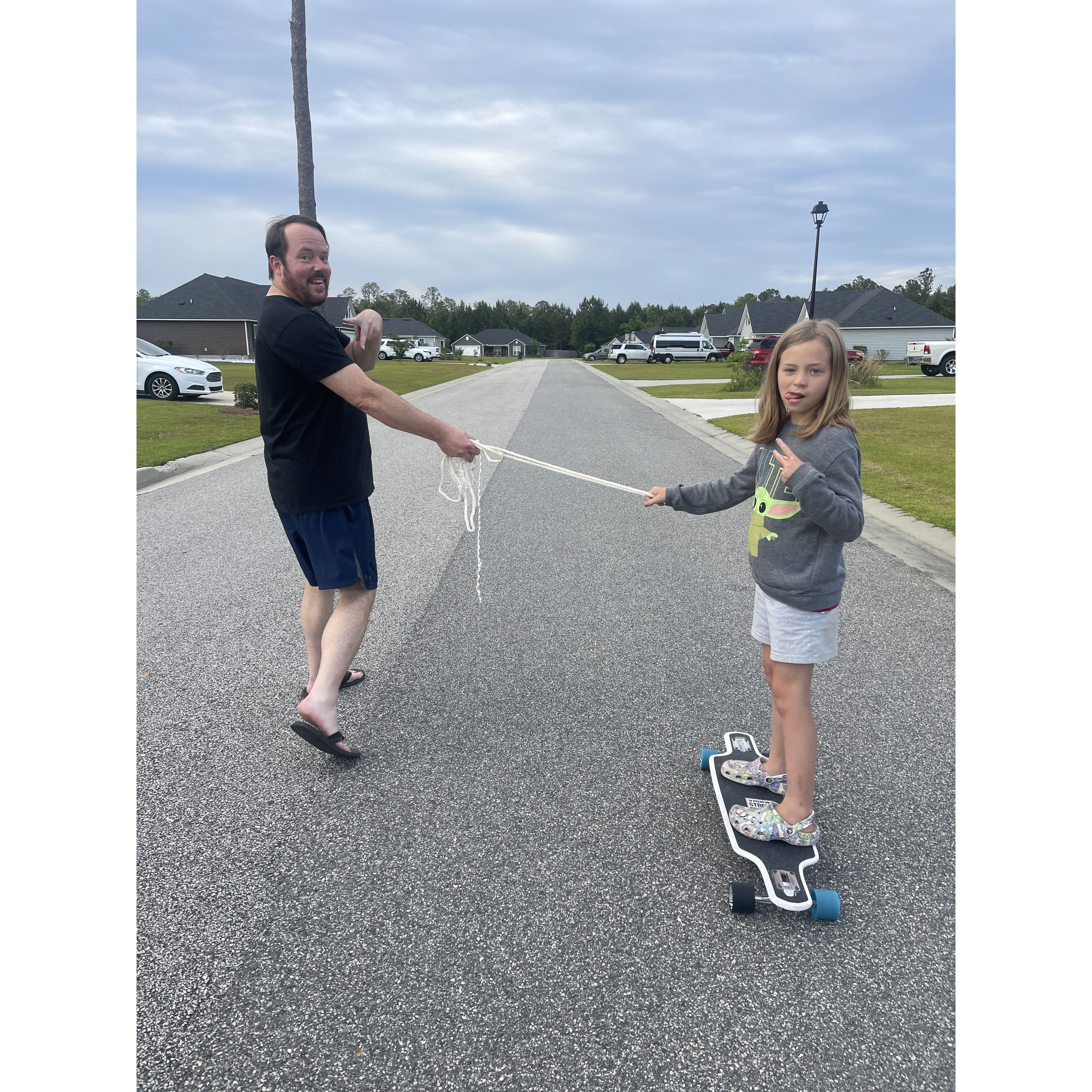 Scott teaching Kinsley how to skateboard.