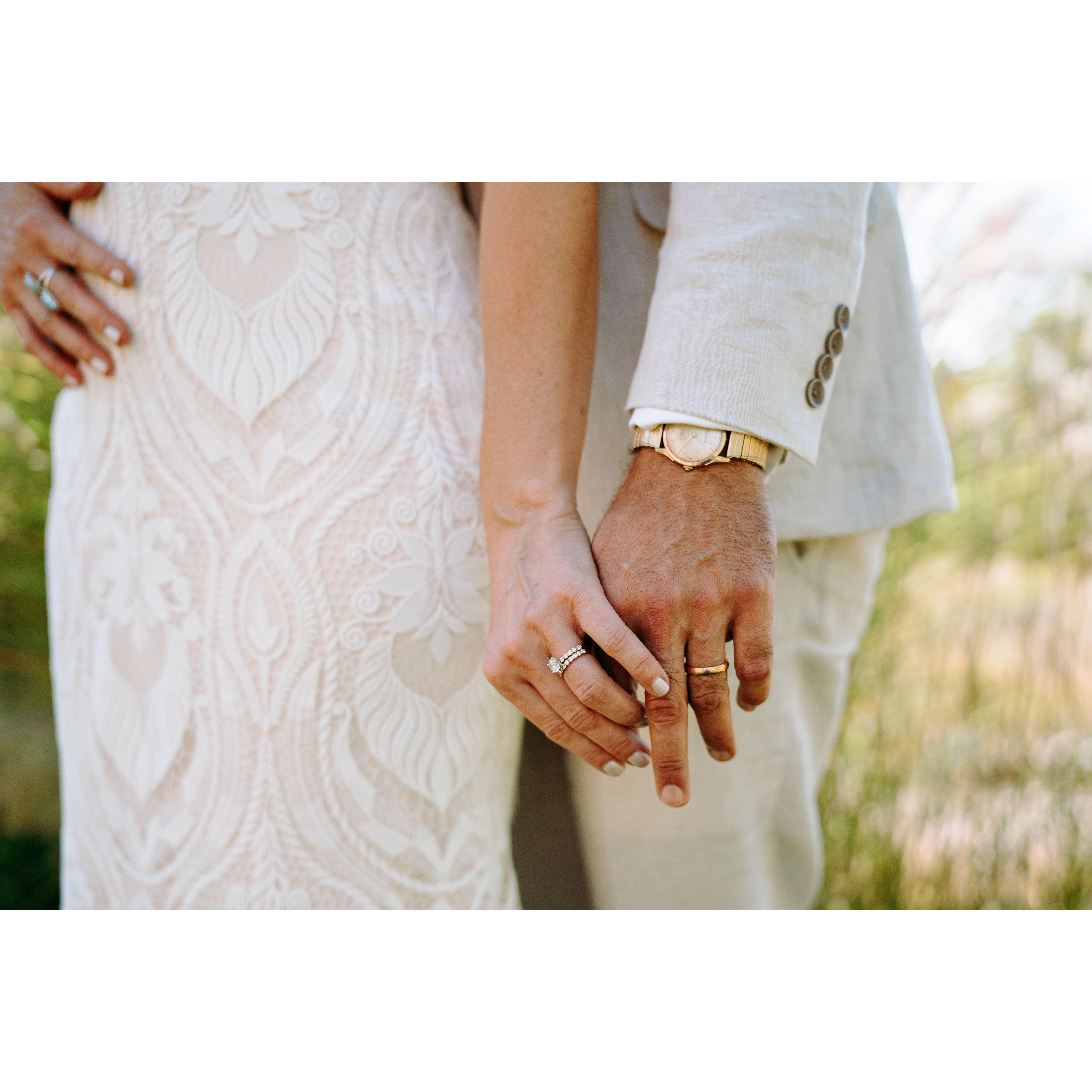 Jenn and Shae hold hands with their wedding rings showing