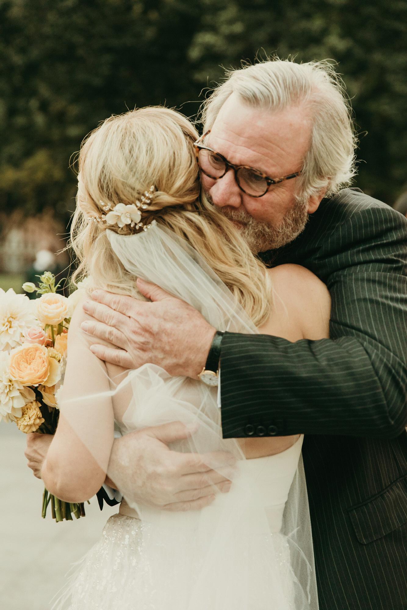 Rosebud hugging her Dad Jamie the wedding ceremony. Photo by @purroy_photo_video